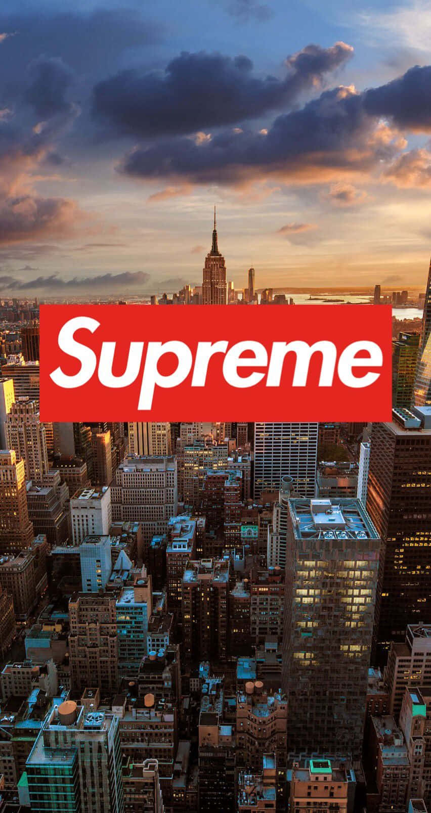 supreme aesthetic 桌布 壁紙 — 紐約市天際線的 vibrant 日落，帝國大廈清晰可見，並有醒目的紅色 Supreme 標誌覆蓋。