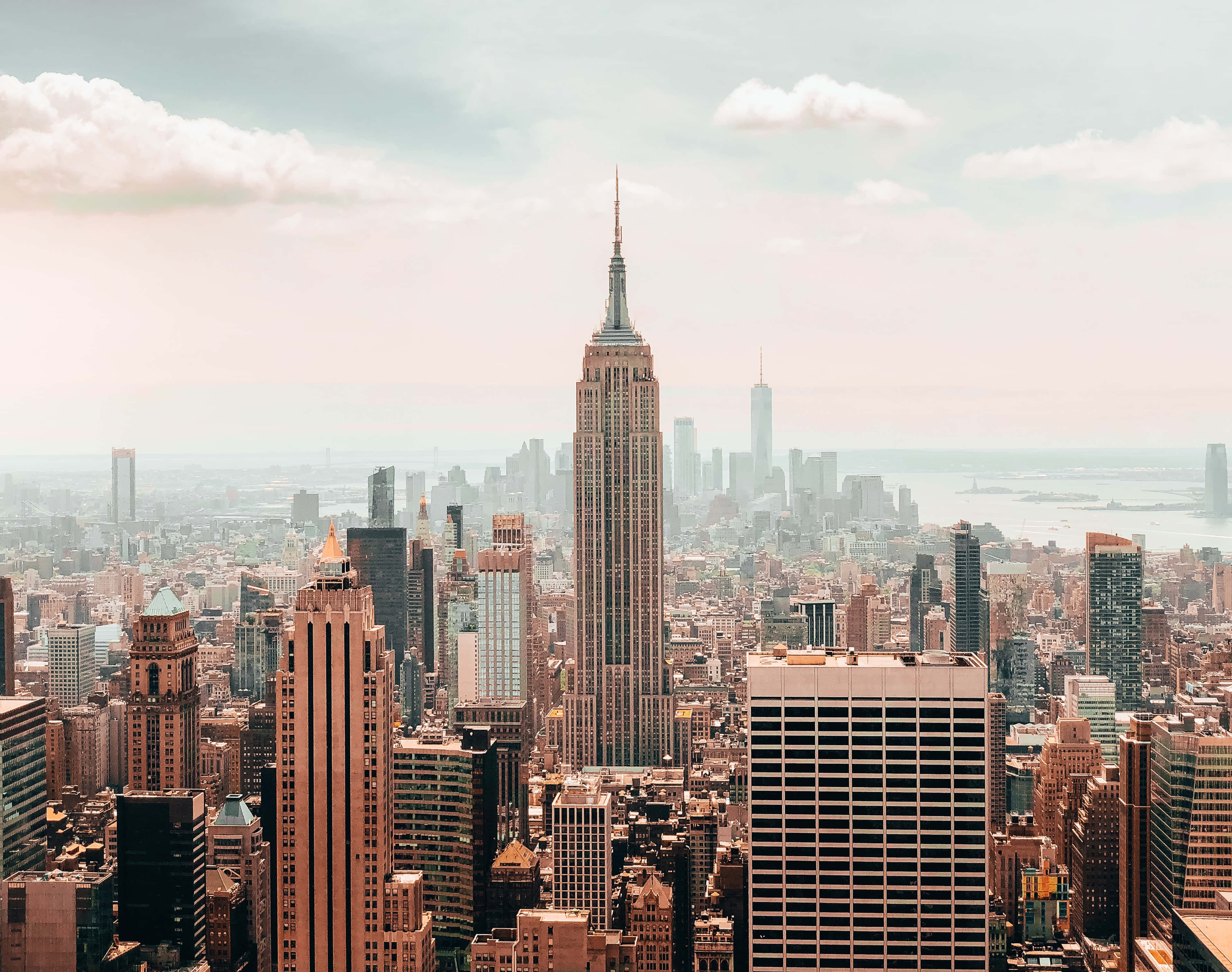 Empire State Building 桌布 壁紙 — 紐約市天際線的全景視圖，以帝國大廈為主導，天空柔和多雲。