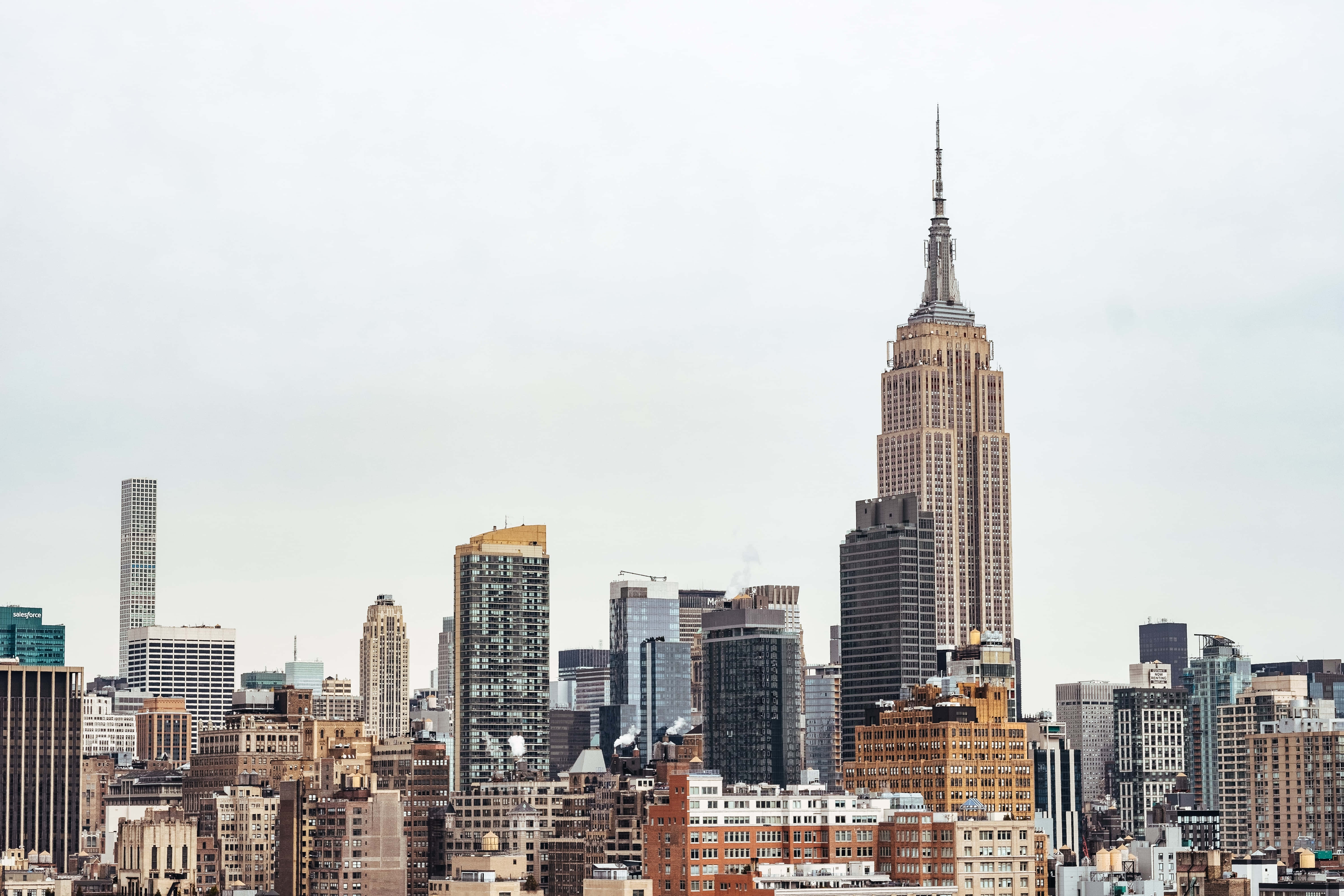 Empire State Building 桌布 壁紙 — 紐約市天際線的全景視圖，以標誌性的帝國大廈為主導，天空多雲。