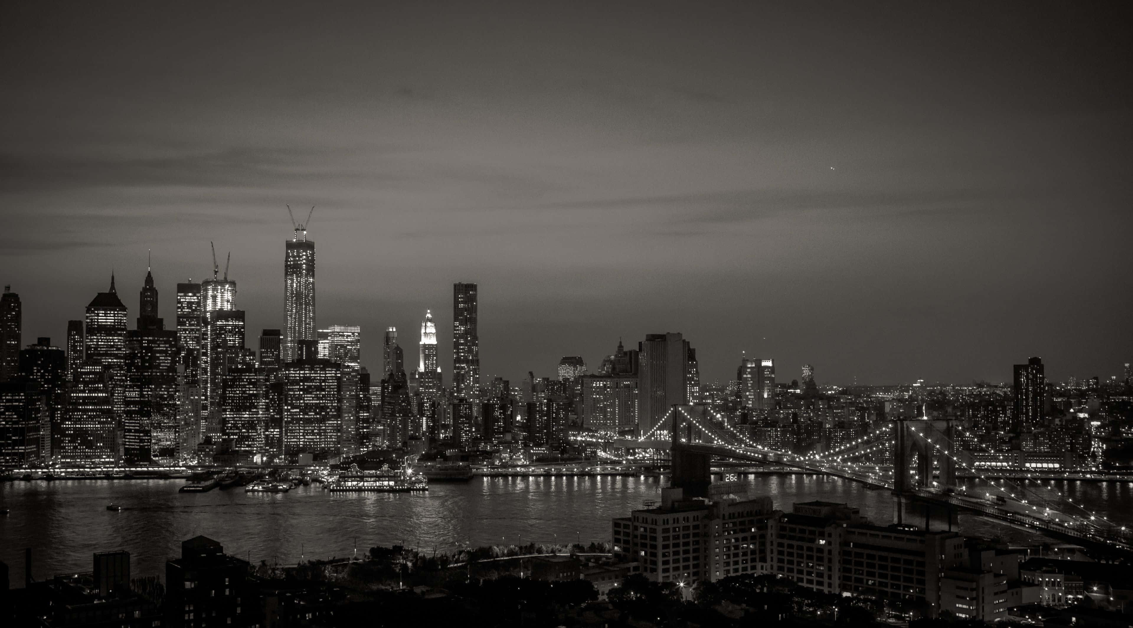 New York 桌布 壁紙 — 紐約市天際線的單色夜間全景，布魯克林大橋在水面上照亮。