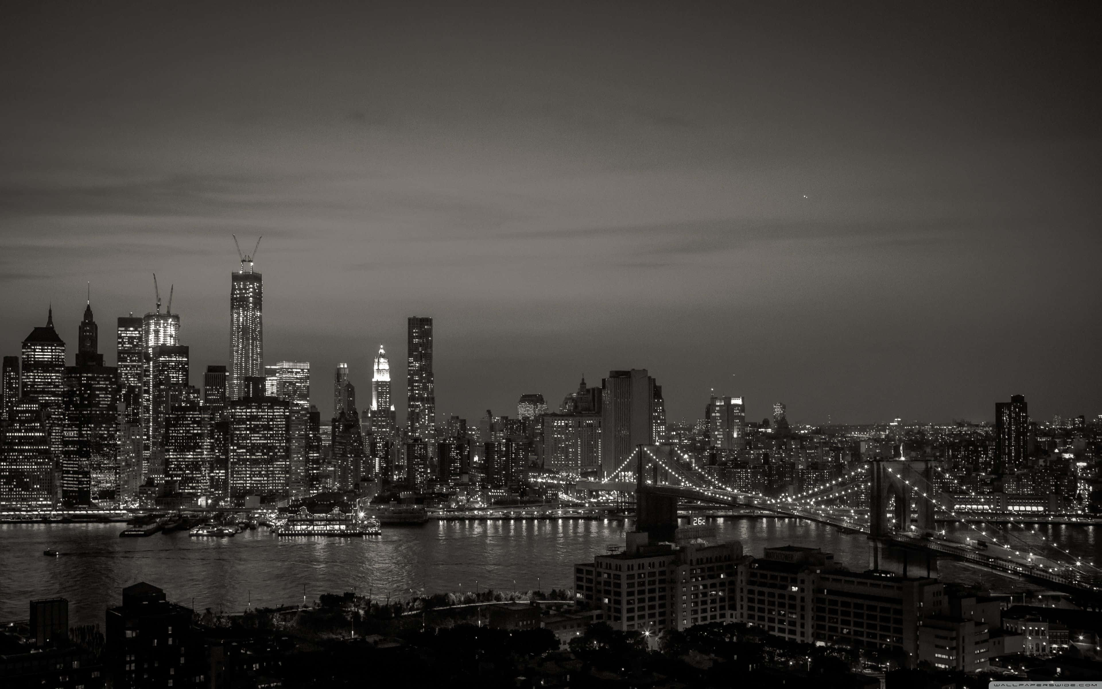 Black And White Aesthetic Pc 桌布 壁紙 — 紐約市天際線的單色夜間全景，布魯克林大橋在水面上照亮。