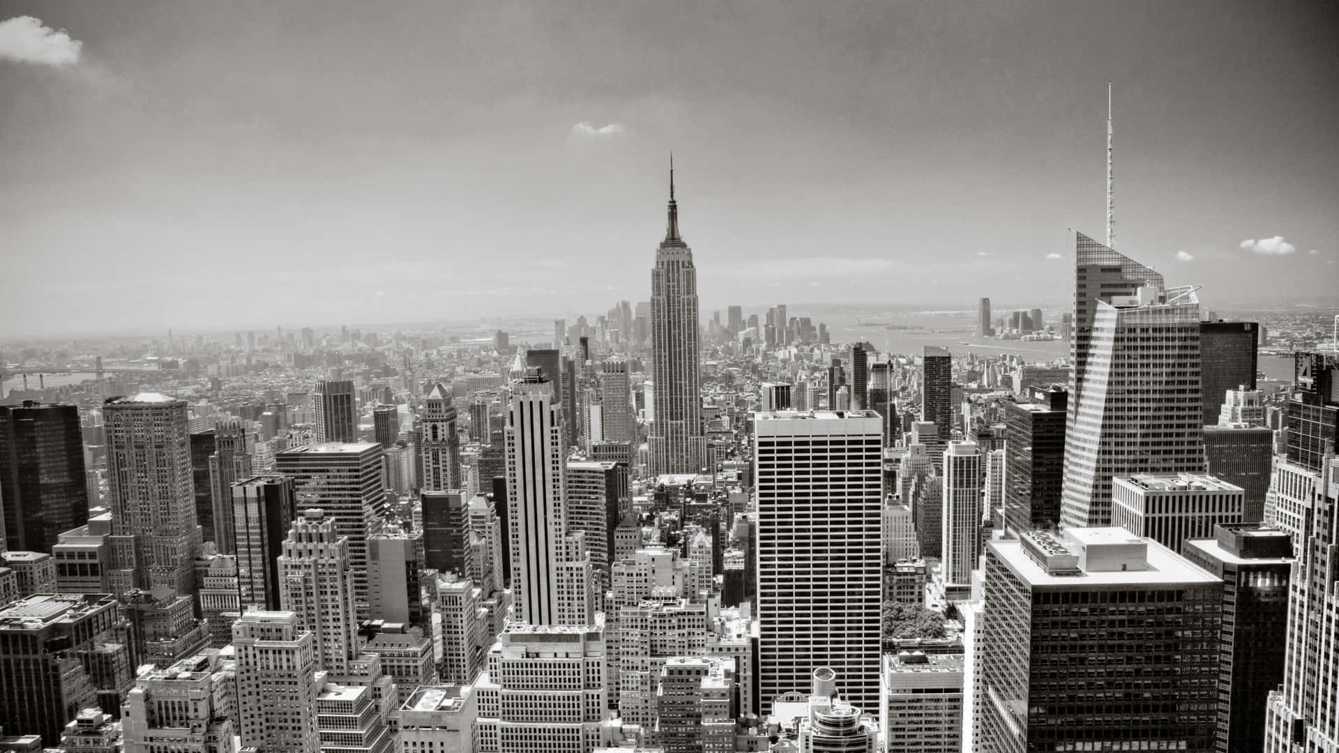 New York 桌布 壁紙 — 紐約市天際線的單色航拍圖，以帝國大廈為主導，天空多雲。