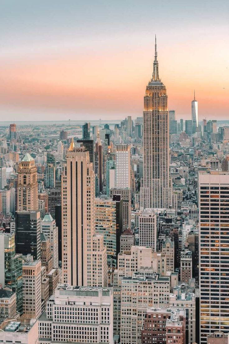 New York 桌布 壁紙 — 紐約市天際線的壯麗日落景觀，以燈火通明的帝國大廈為主導。