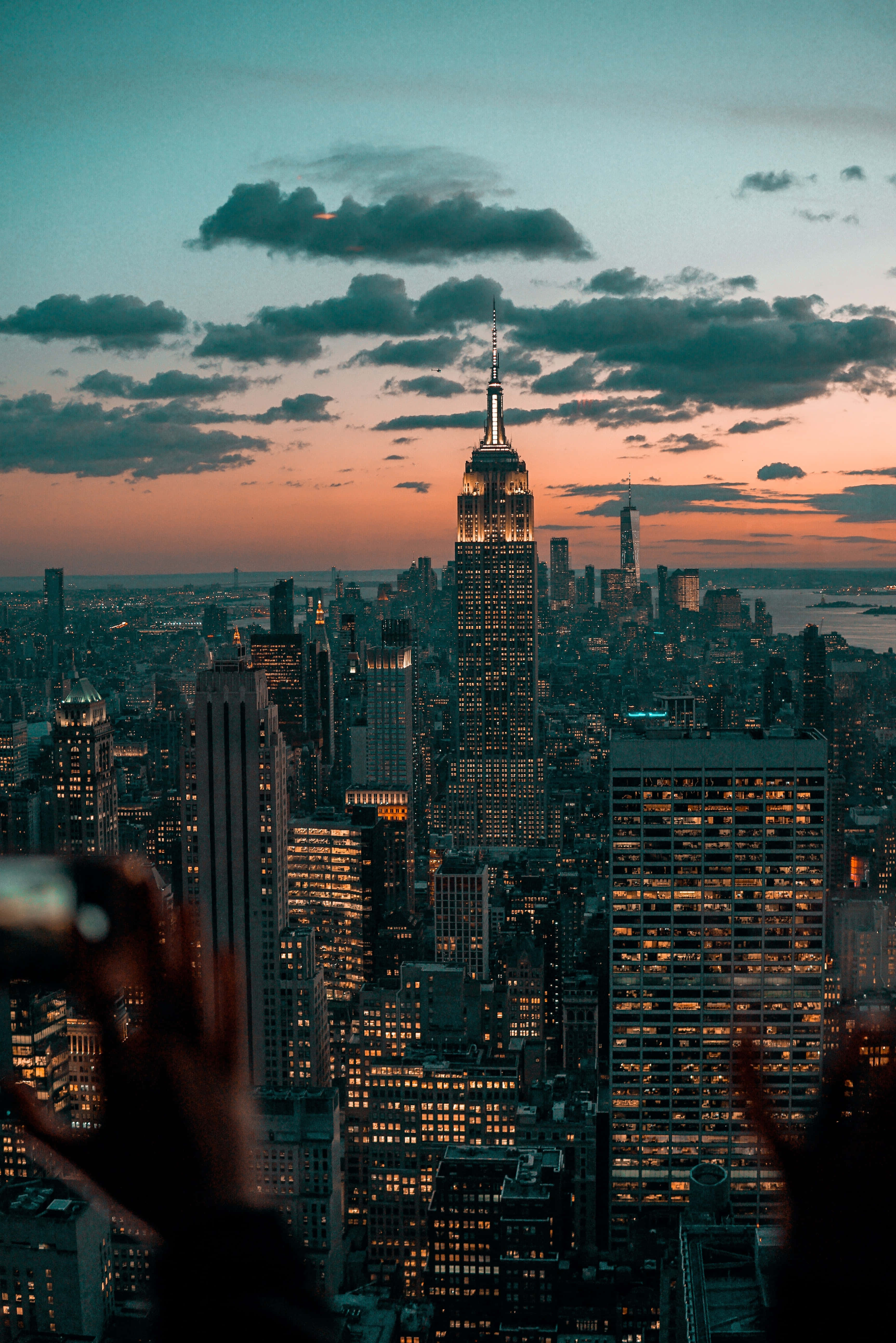 Empire State Building 桌布 壁紙 — 紐約市天際線的壯麗暮色景觀，帝國大廈在橙色和青綠色的雲彩中閃耀。