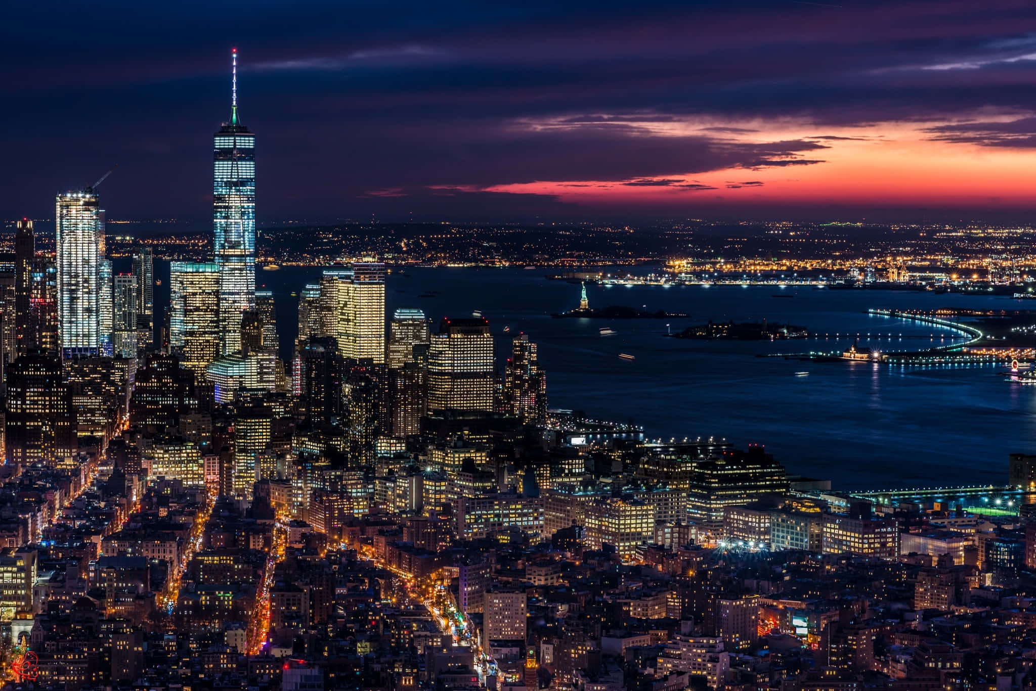 New York City 4K Ultra HD 桌布 壁紙 — 紐約市天際線的壯麗暮色景觀，摩天大樓和港口在充滿活力的紫色和橙色天空下閃耀。