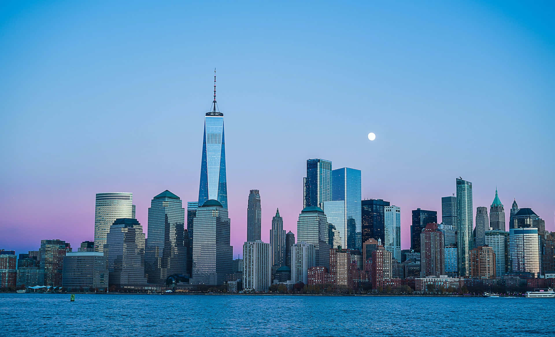 Skyscraper 桌布 壁紙 — 紐約市天際線的壯麗暮色景觀，月亮升起於世界貿易中心一號大樓及周圍摩天大樓之上，倒映在水中。