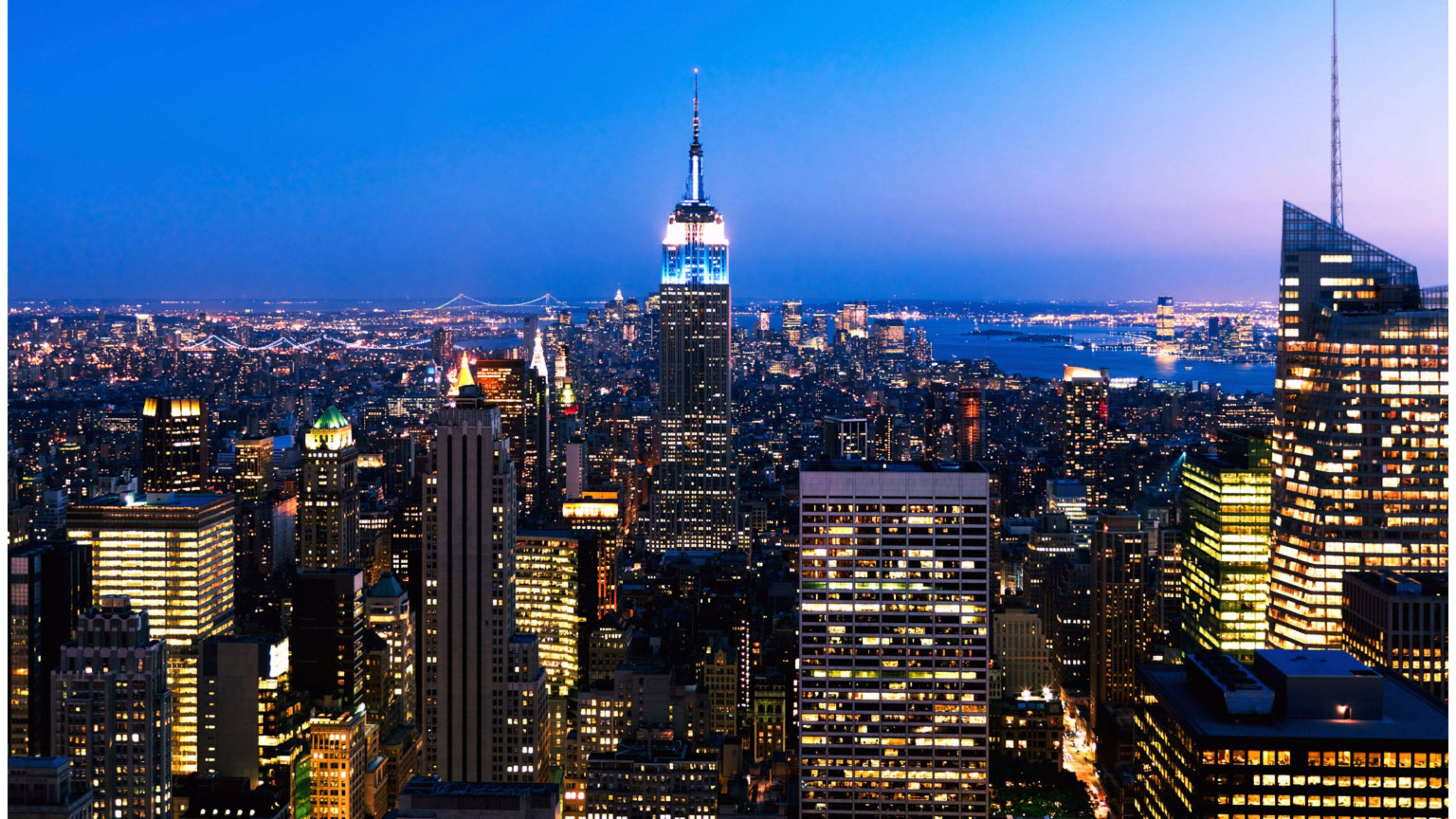 4K New York City 桌布 壁紙 — 紐約市天際線的壯麗黃昏景色，帝國大廈在深藍色天空下閃耀。