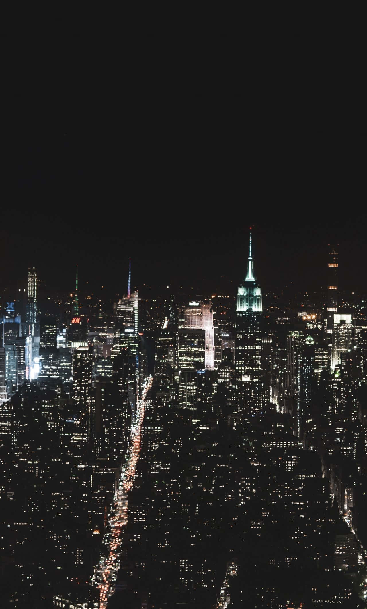 Buildings 桌布 壁紙 — 紐約市天際線的夜間空中景觀，下方是閃閃發光的摩天大樓和燈火通明的街道。