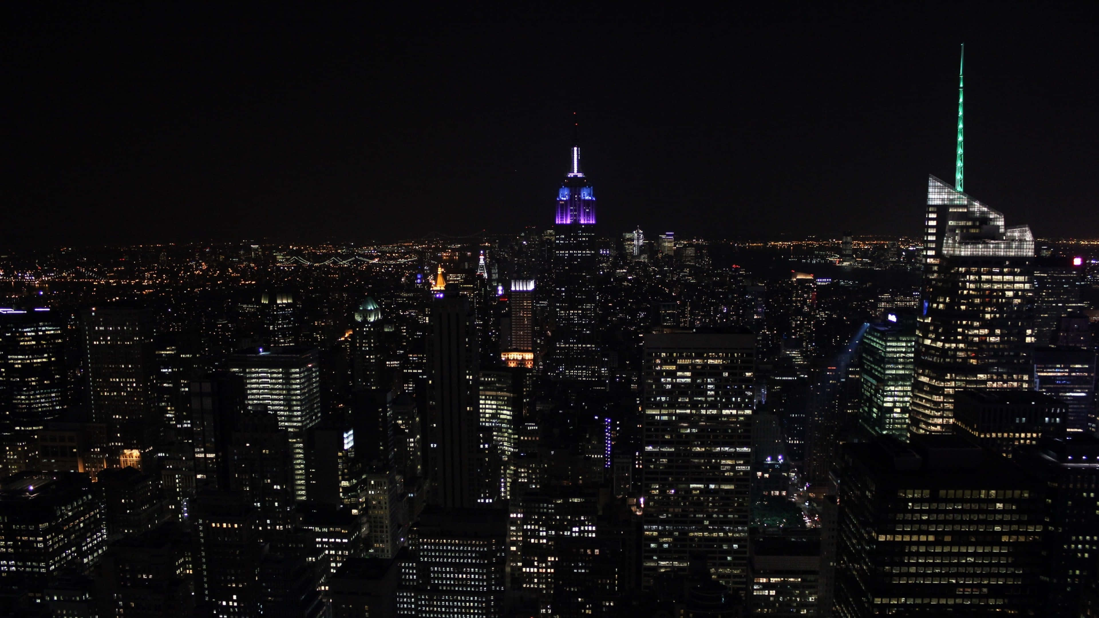New York City 4K Ultra HD 桌布 壁紙 — 紐約市天際線的夜間空中景觀，高樓大廈燈火通明，窗戶在黑暗的天空中閃閃發光。