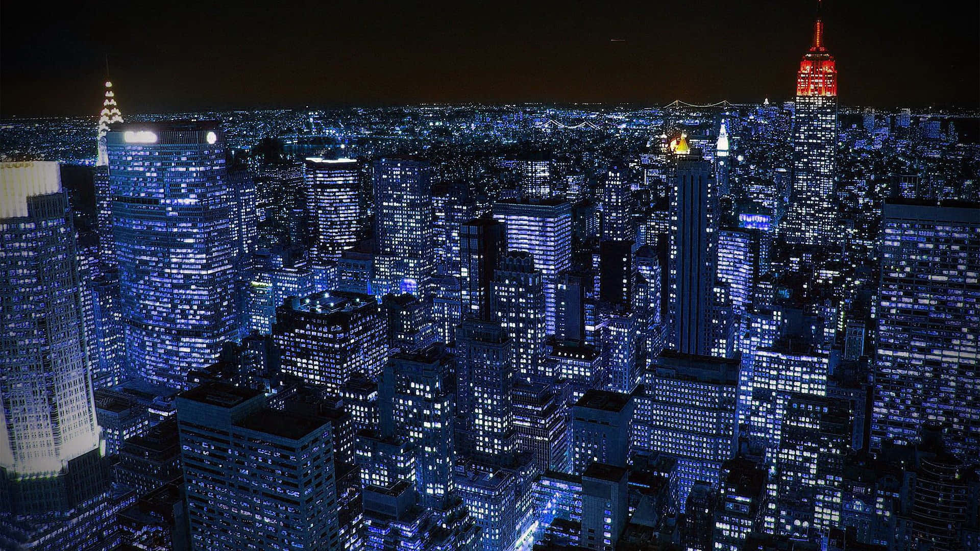 New York 桌布 壁紙 — 紐約市天際線的夜間空拍圖，無數窗戶散發出藍色和白色的光芒。
