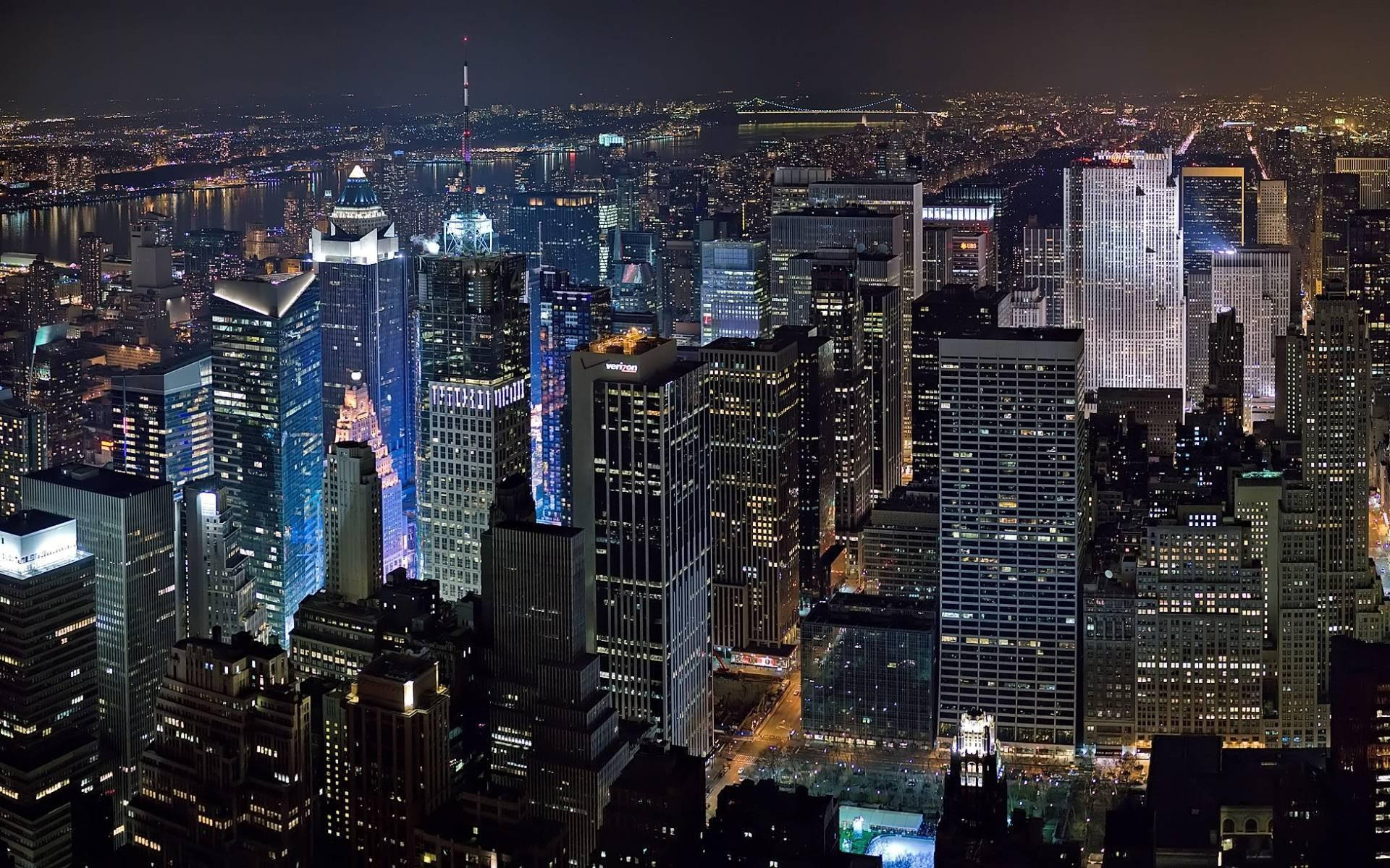Nyc Aesthetic 桌布 壁紙 — 紐約市天際線的夜間航拍圖，下方是燈火通明的摩天大樓和發光的街道。