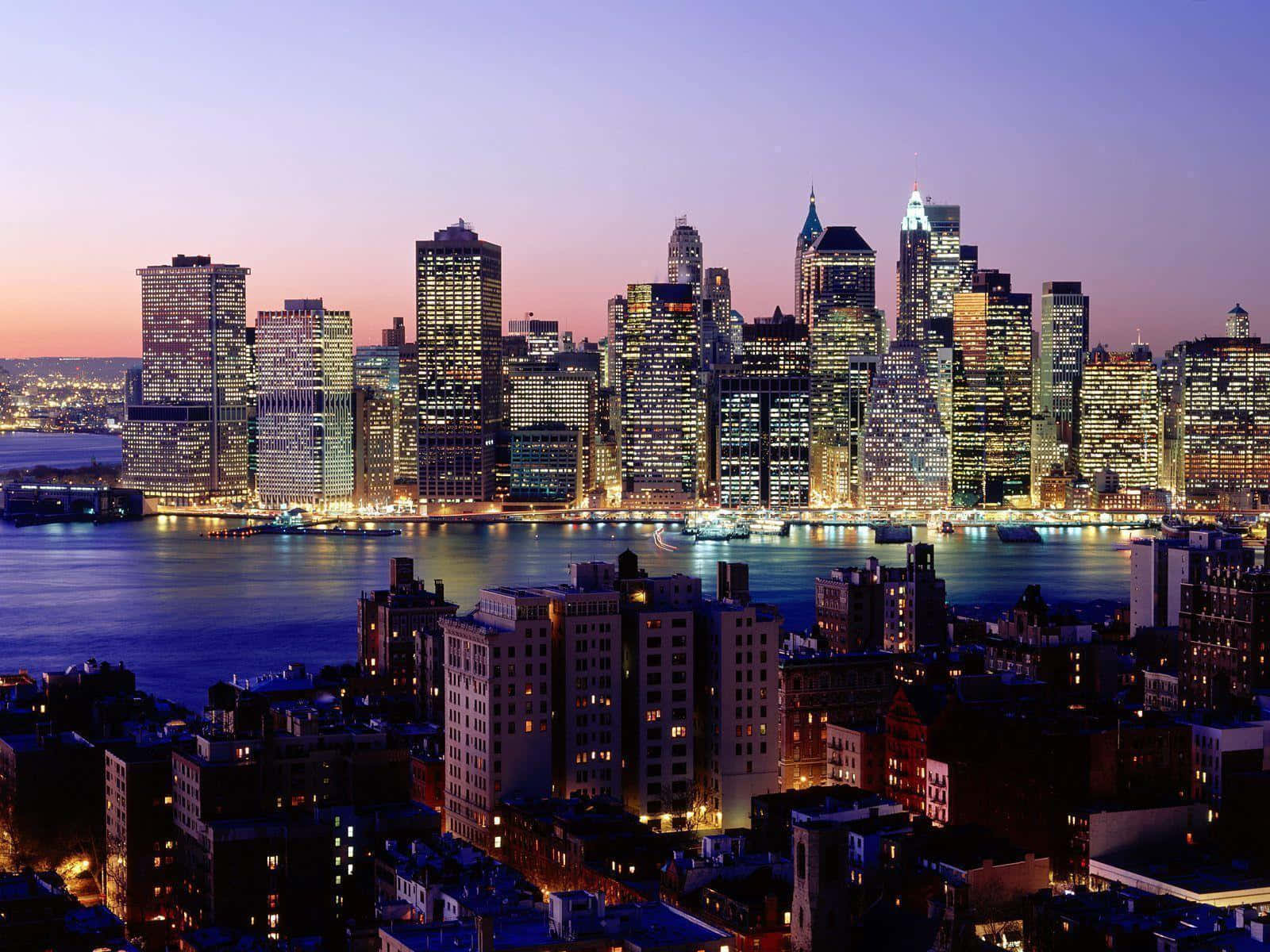 New York 桌布 壁紙 — 紐約市天際線的迷人黃昏景色，閃爍的摩天大樓倒映在水面上。