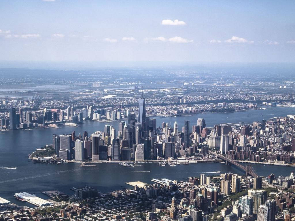 Skyscraper 桌布 壁紙 — 紐約市天際線的鳥瞰圖，包括摩天大樓、橋樑和水域，在清澈的藍天下。