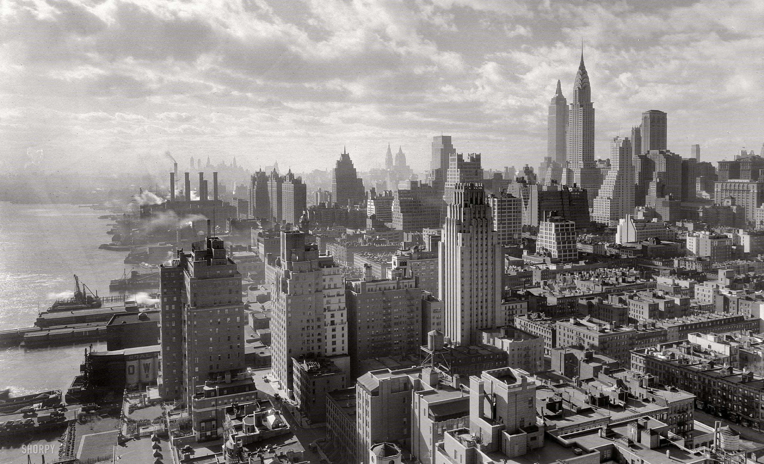 New York 桌布 壁紙 — 紐約市天際線的黑白空拍圖，克萊斯勒大廈聳立於密集的城市建築和海濱工業之上。