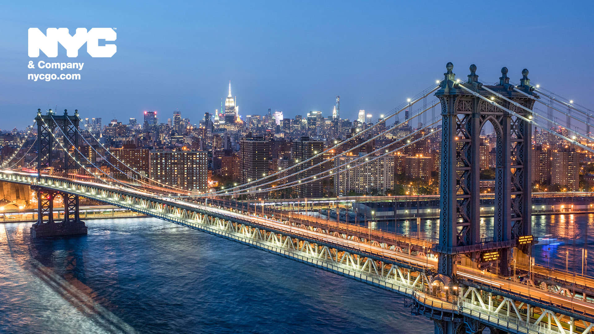 manhattan 桌布 壁紙 — 紐約市曼哈頓大橋的壯麗黃昏景色，城市燈光在水面上閃爍倒映。