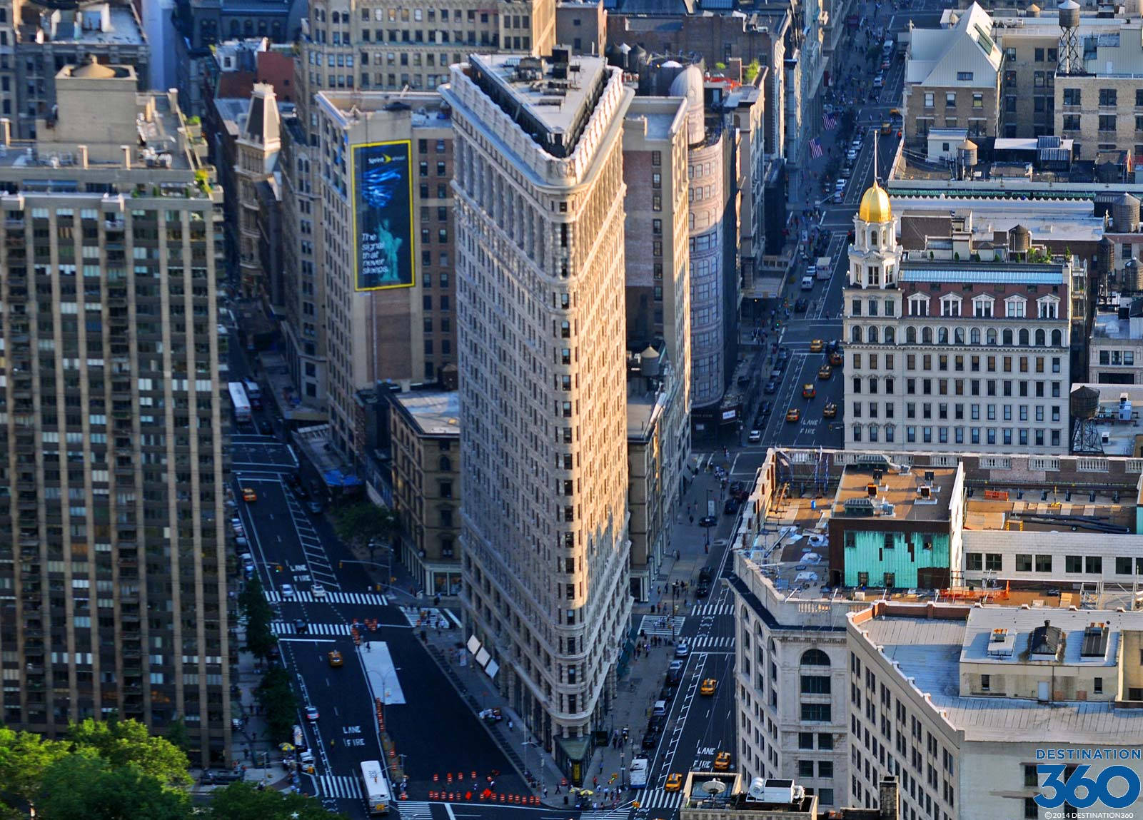 Flatiron Building 桌布 壁紙 — 紐約市熨斗大廈的鳥瞰圖，沐浴在黃金時段的光線中，下方是繁忙的街道和黃色的士。