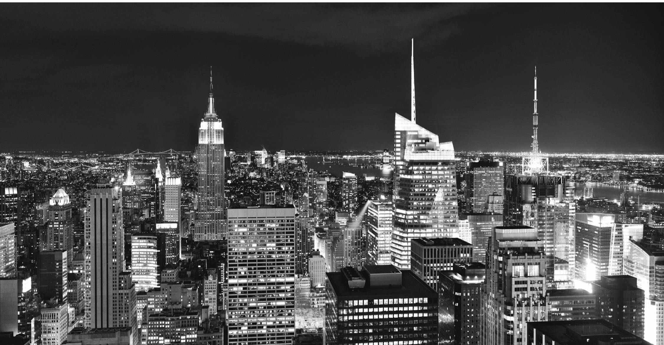 New York 桌布 壁紙 — 紐約市燈火通明的摩天大樓和密集城市網格的醒目黑白夜景全景。