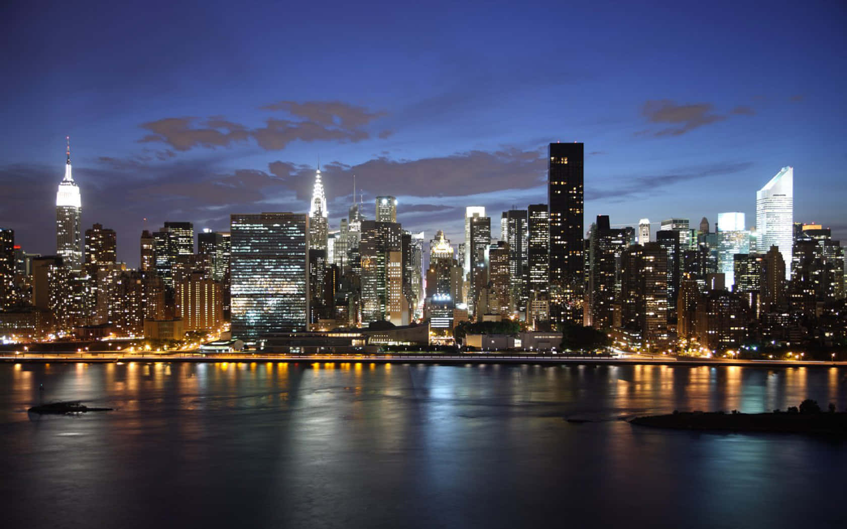 New York 桌布 壁紙 — 紐約市璀璨的天際線在下方平靜的水面上倒映出的迷人黃昏景色。