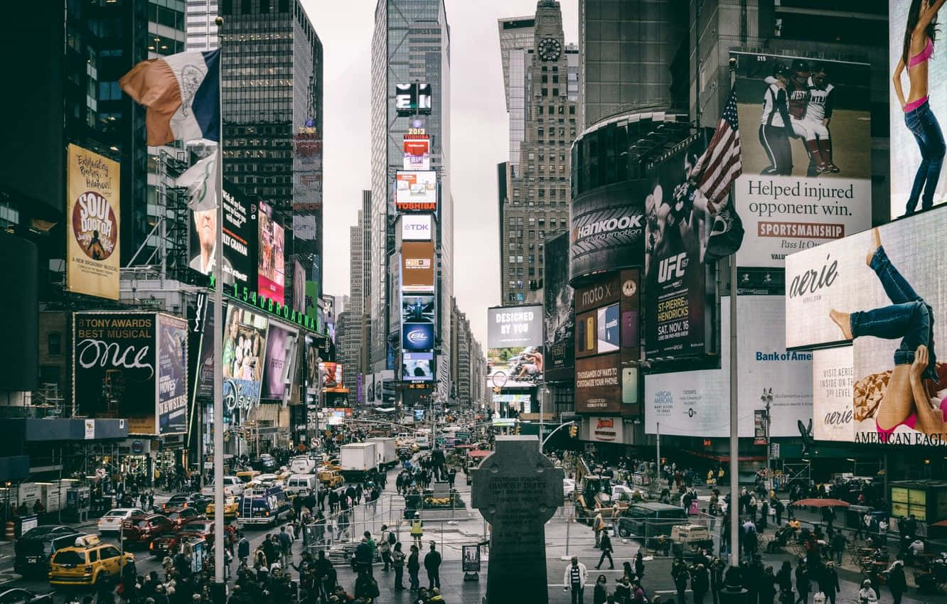 New York 桌布 壁紙 — 紐約市繁華的時代廣場，佈滿高聳的廣告牌、人群和黃色的士，天空多雲。