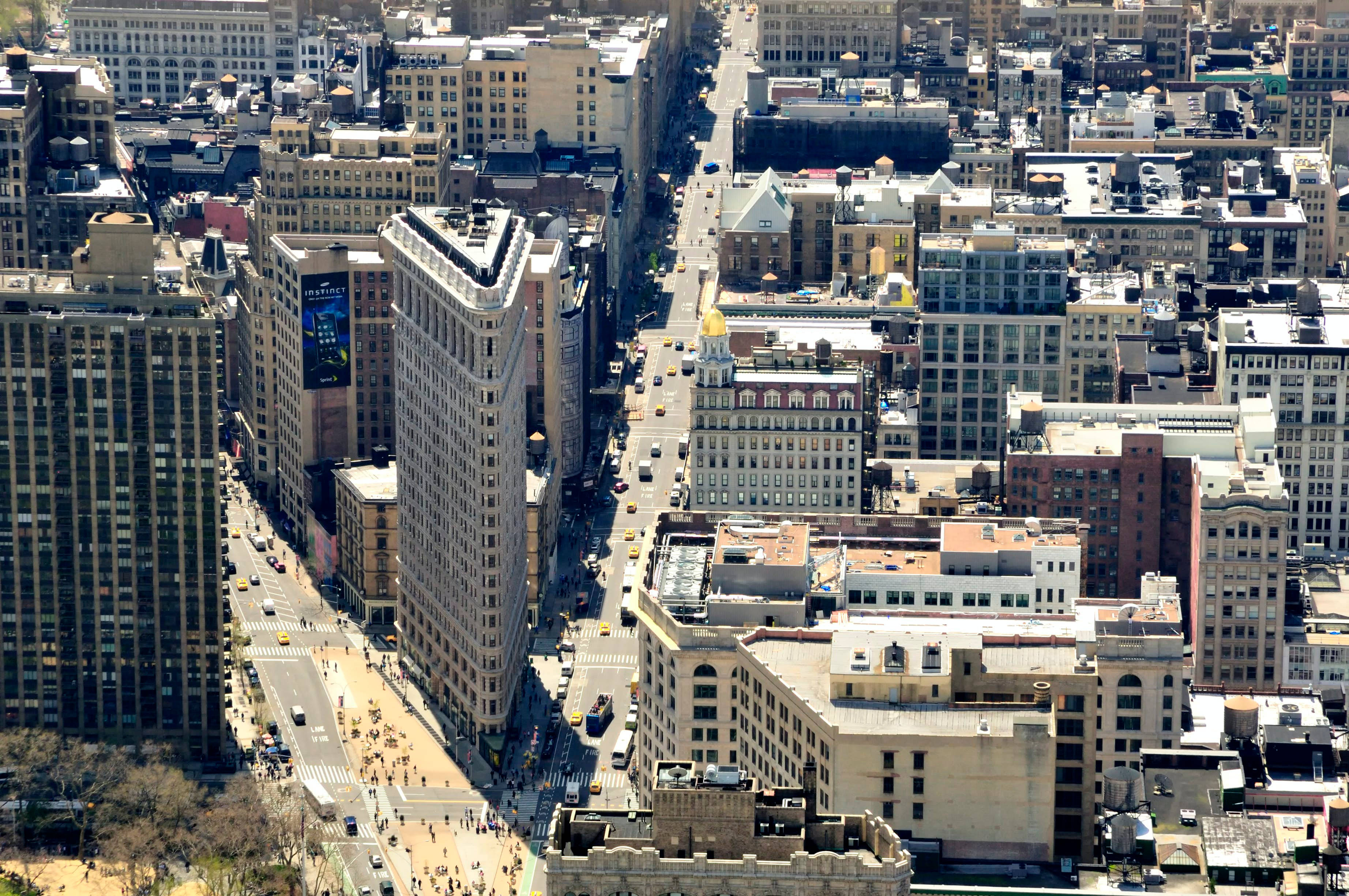 Flatiron Building 桌布 壁紙 — 紐約市街道的鳥瞰圖，在標誌性的熨斗大廈周圍，交通和行人熙熙攘攘。