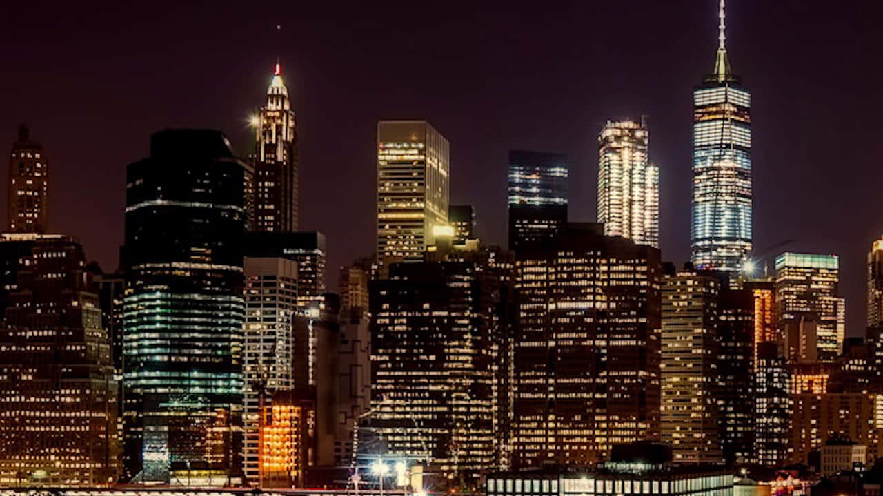 夜景城市 桌布 壁紙 — 紐約摩天大樓在黑暗天空下閃耀著冷暖燈光的迷人夜景。