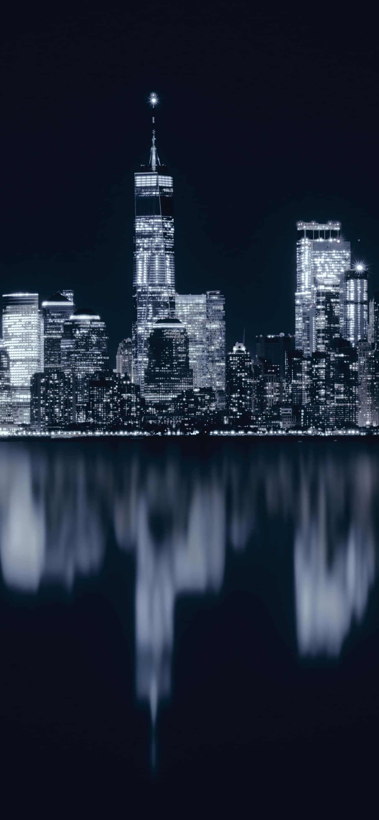 New York City Night iPhone 桌布 壁紙 — 紐約的單色夜景，摩天大樓及其燈光倒映在暗水中。