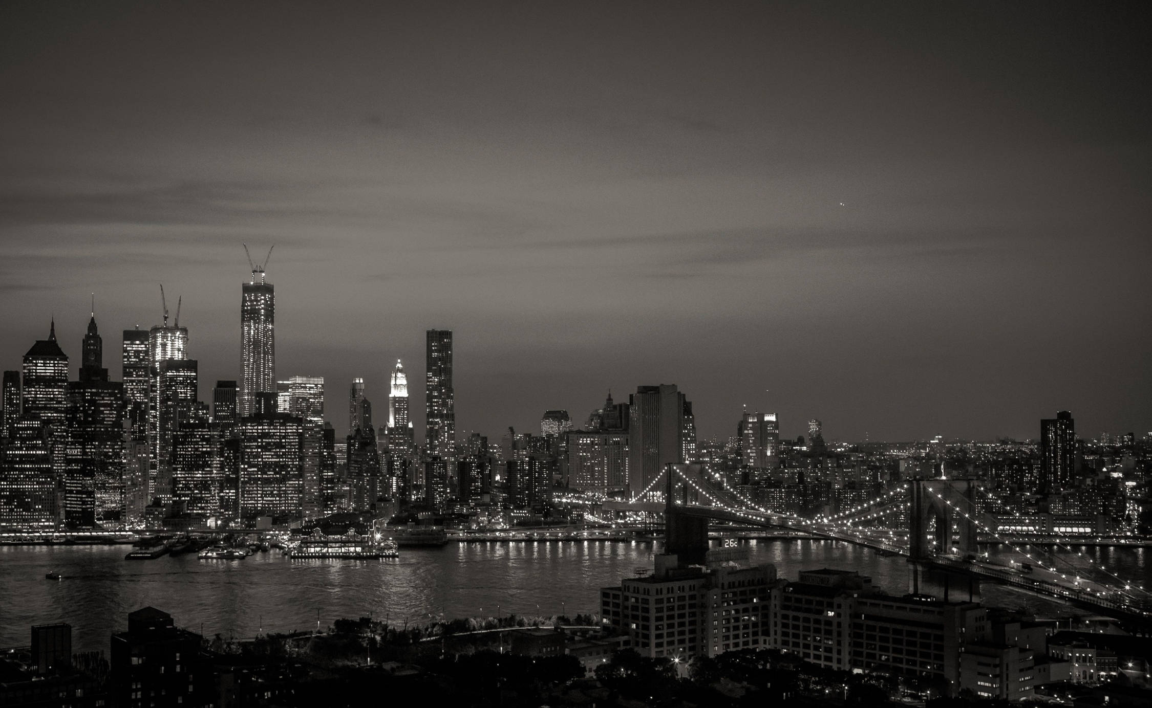 New York 桌布 壁紙 — 紐約的單色夜景，照亮的高樓大廈和布魯克林大橋橫跨河流。