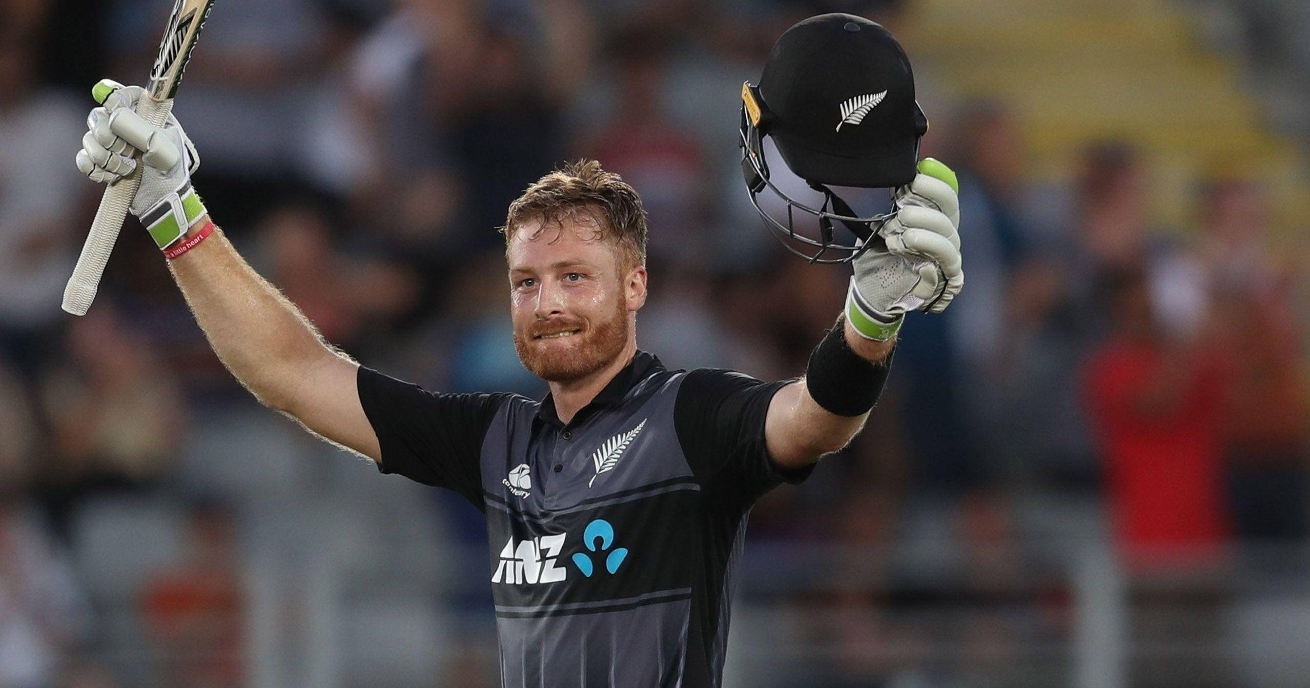 martin guptill 桌布 壁紙 — 紐西蘭板球運動員在明亮的燈光下於體育場高舉球棒和頭盔慶祝勝利。