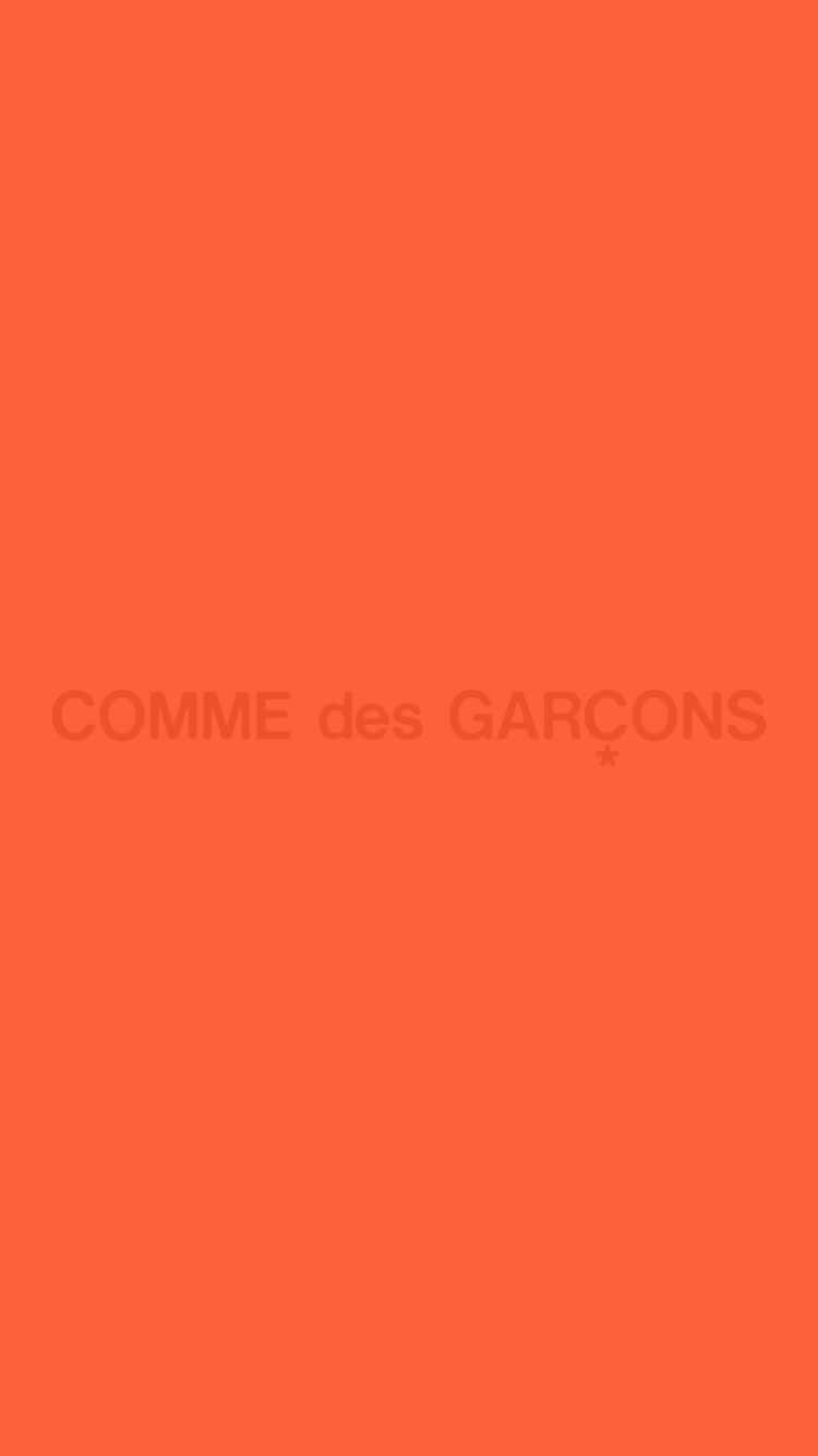 手機 桌布 壁紙 — 純橙色背景，中央有模糊文字寫著COMME des GARÇONS。