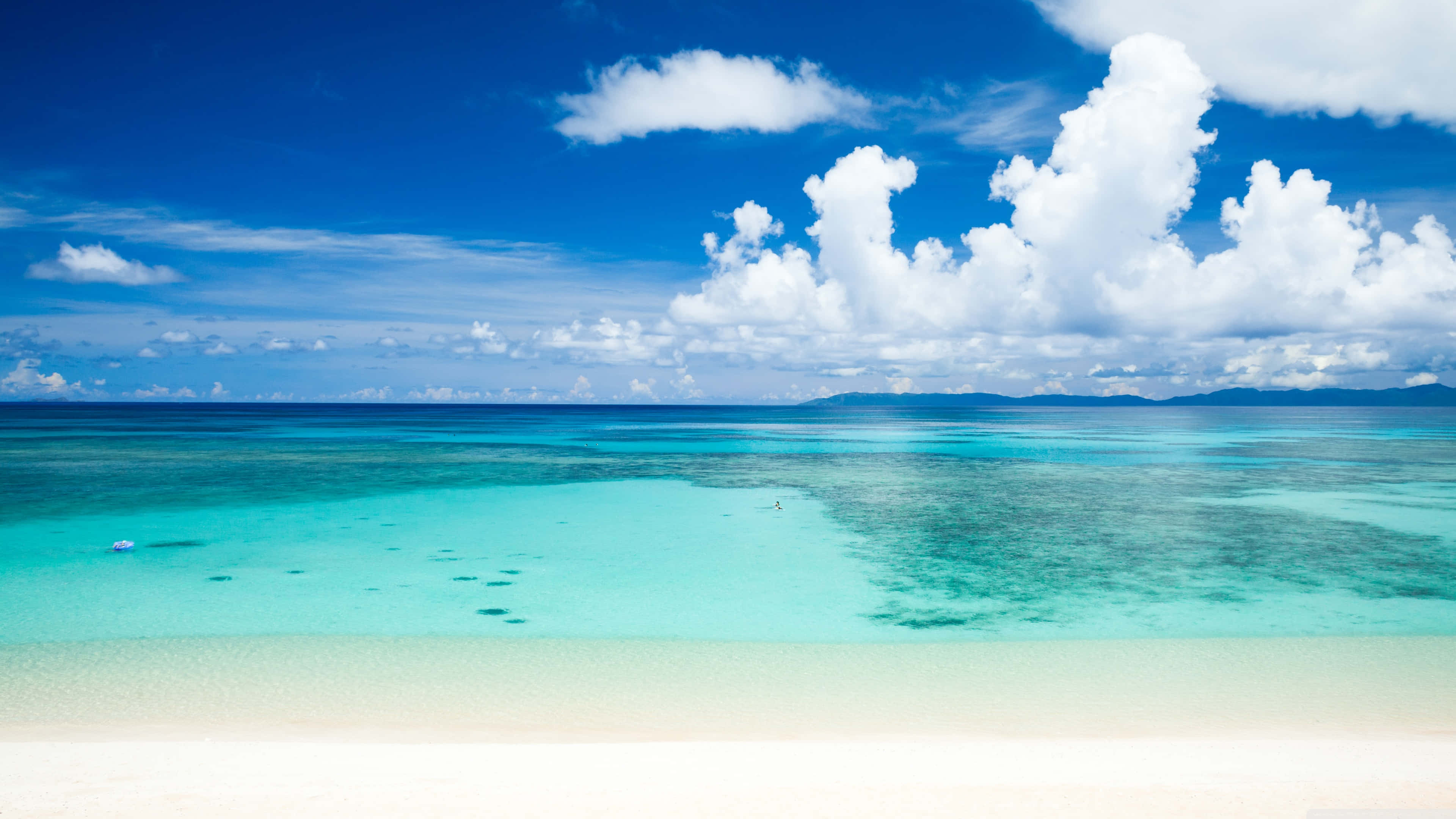 1920x1080 HD Beach 桌布 壁紙 — 純淨的白色沙灘與清澈碧綠的海水相遇，在蔚藍的天空下，飄著蓬鬆的白雲。