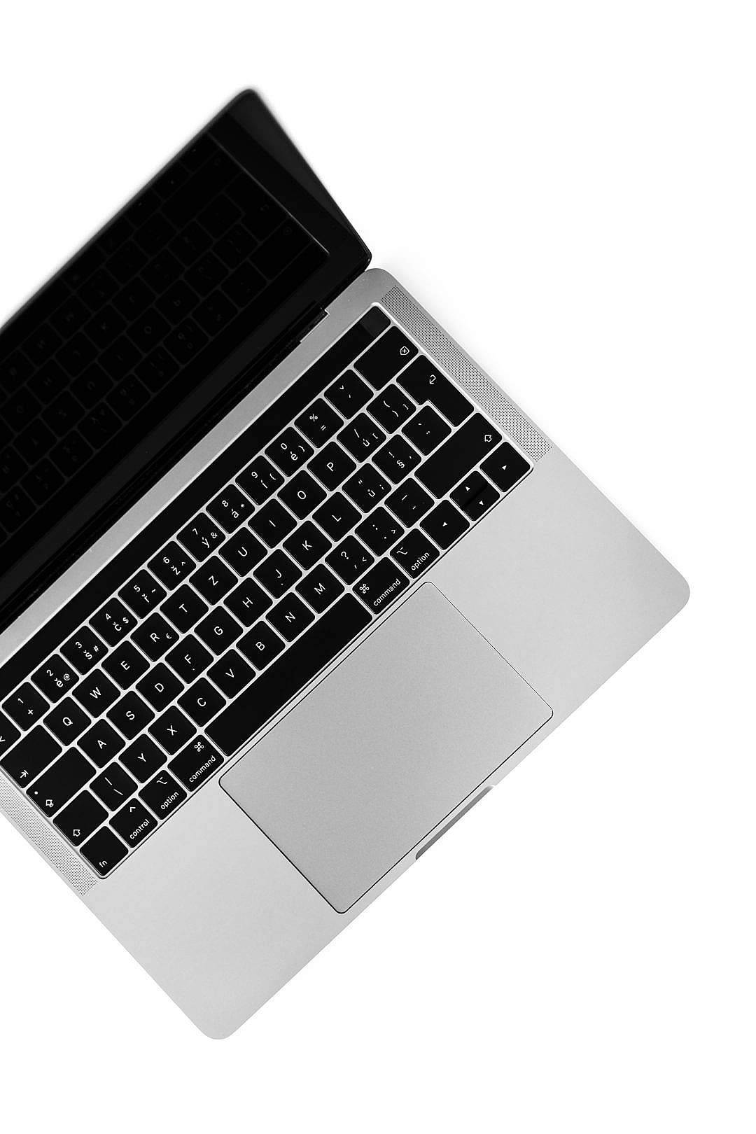 Macbook Air 2020 桌布 壁紙 — 純白背景上，一部時尚銀色筆記型電腦的俯視圖，配備黑色鍵盤。