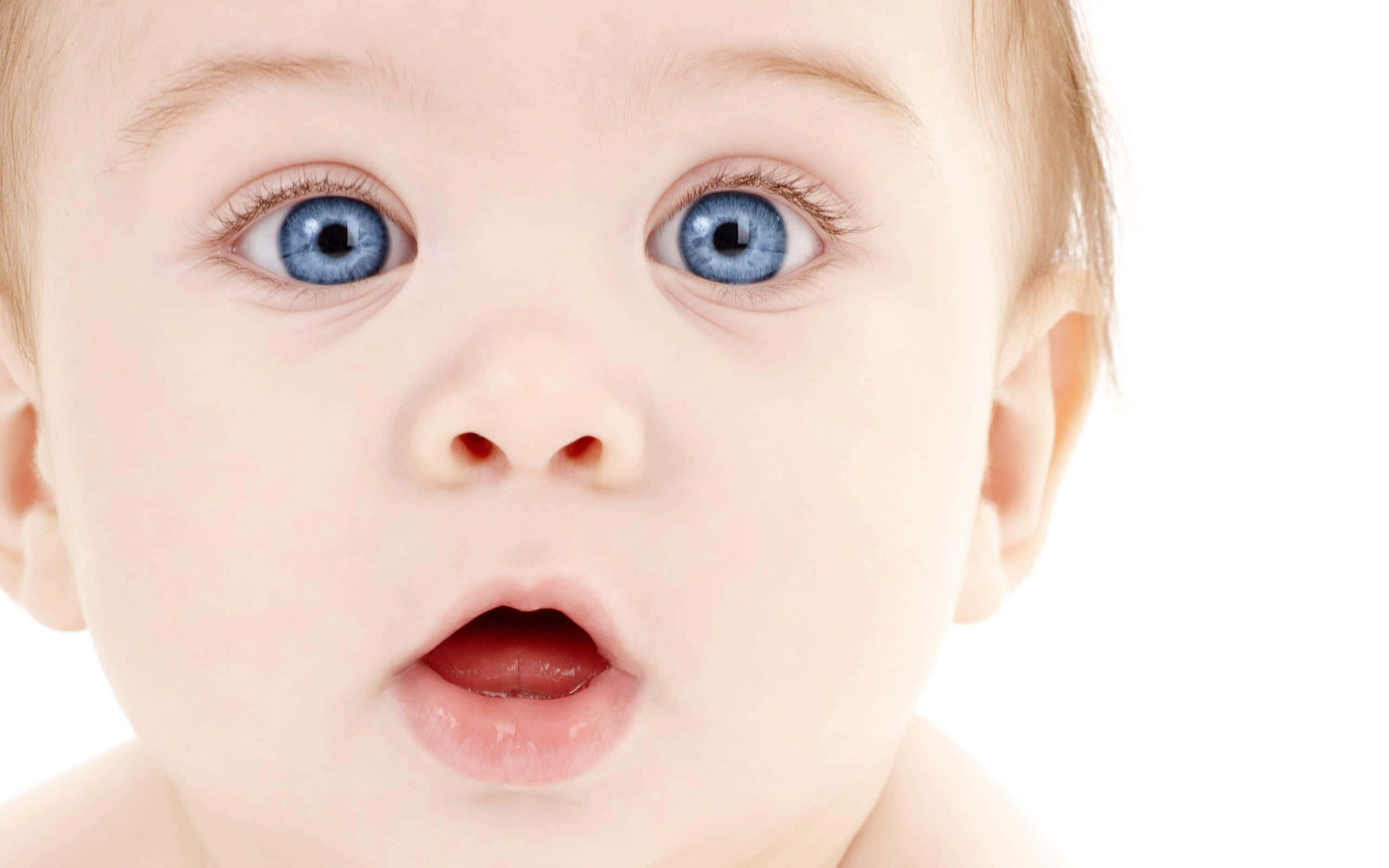 cute baby 桌布 壁紙 — 純白背景上，嬰兒臉部特寫，擁有寬闊的藍色眼睛和張開的嘴巴。