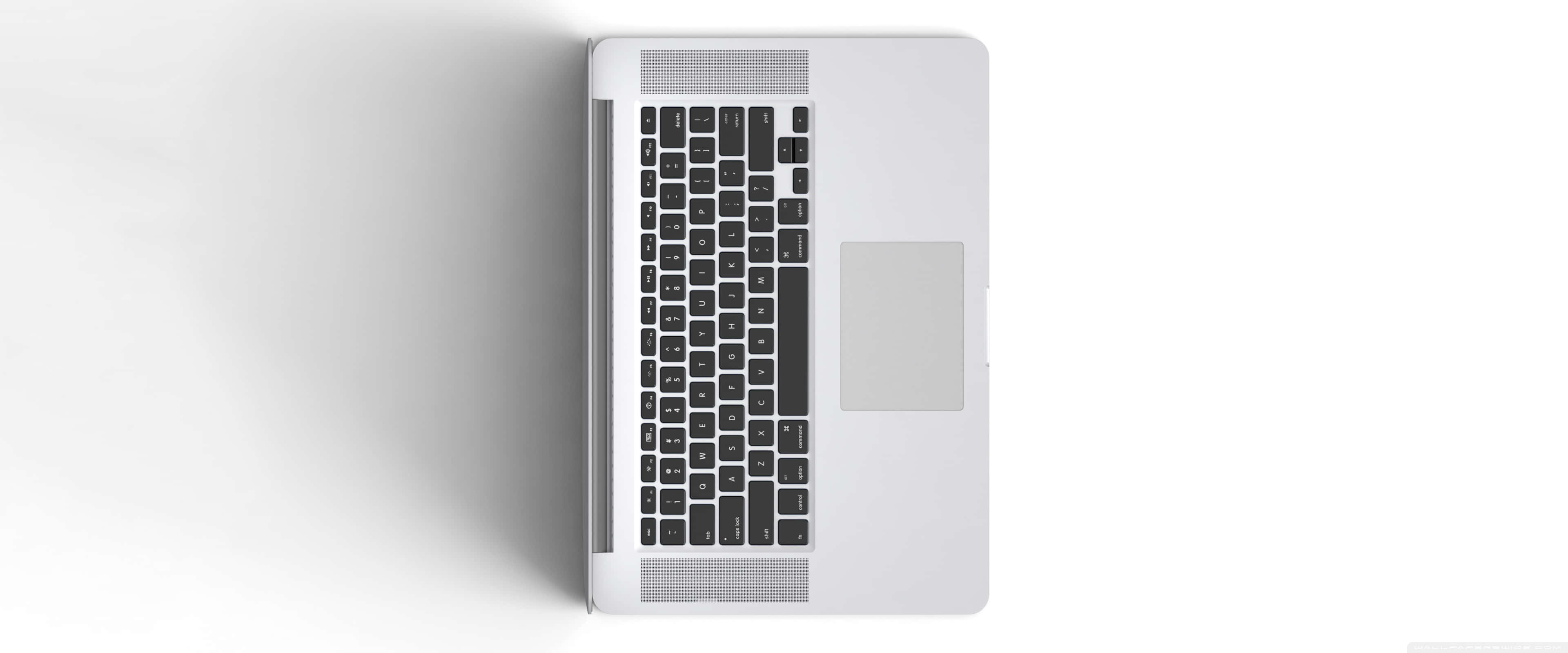 Apple 3840x1600 桌布 壁紙 — 純白色背景上，一部時尚銀色筆記型電腦的俯視圖，配有黑色按鍵和觸控板。