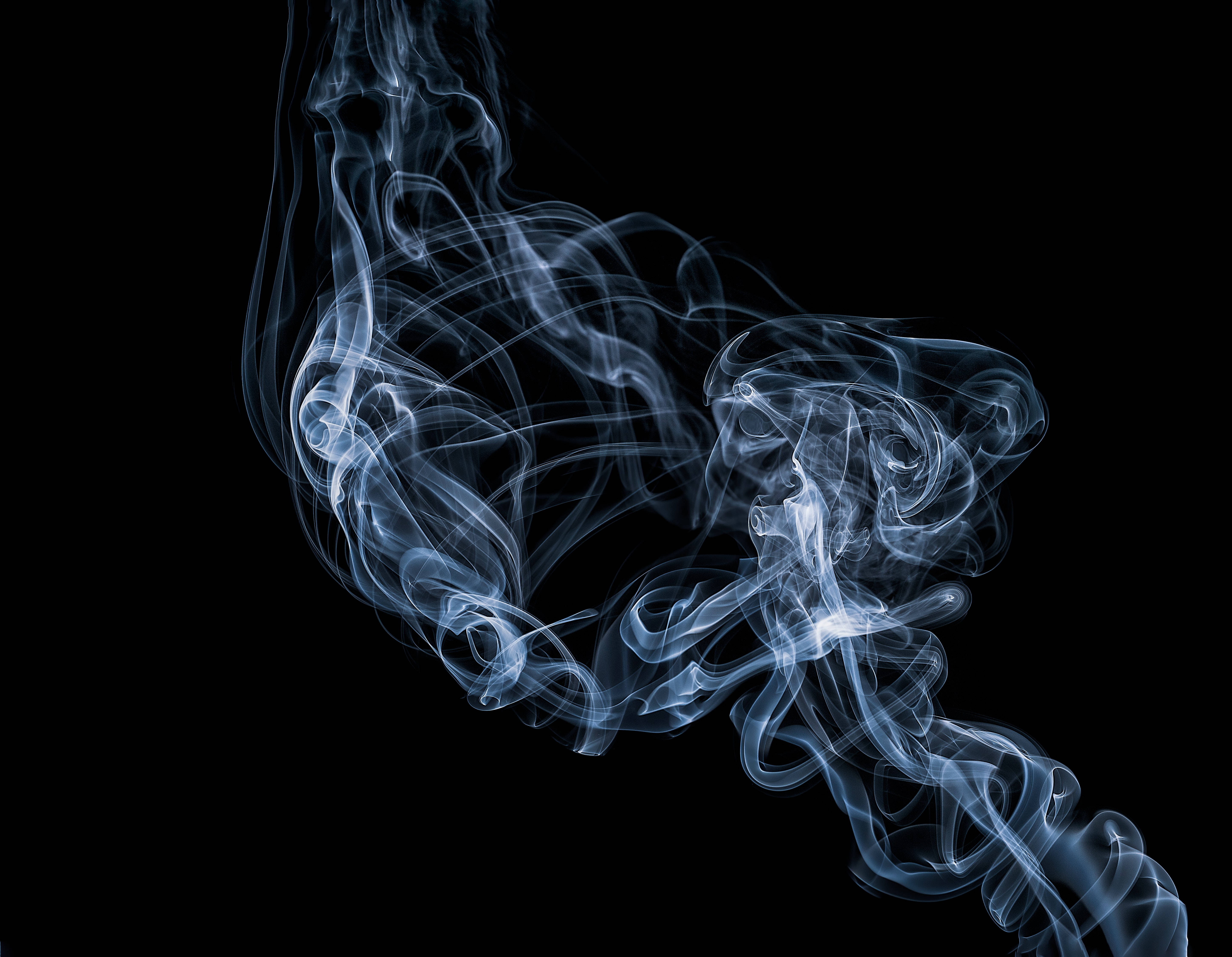 圖案 桌布 壁紙 — 純粹黑色背景上，空靈的藍色煙霧優雅地旋轉，形成動態抽象構圖。