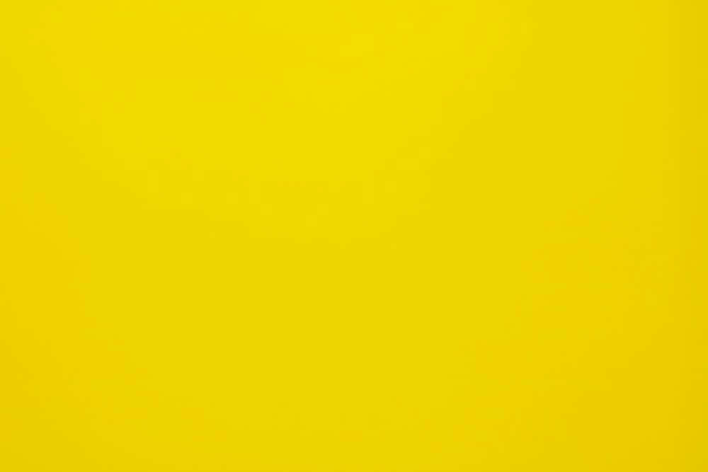Solid Yellow 桌布 壁紙 — 純色鮮黃背景，帶有微妙漸變和柔和紋理。