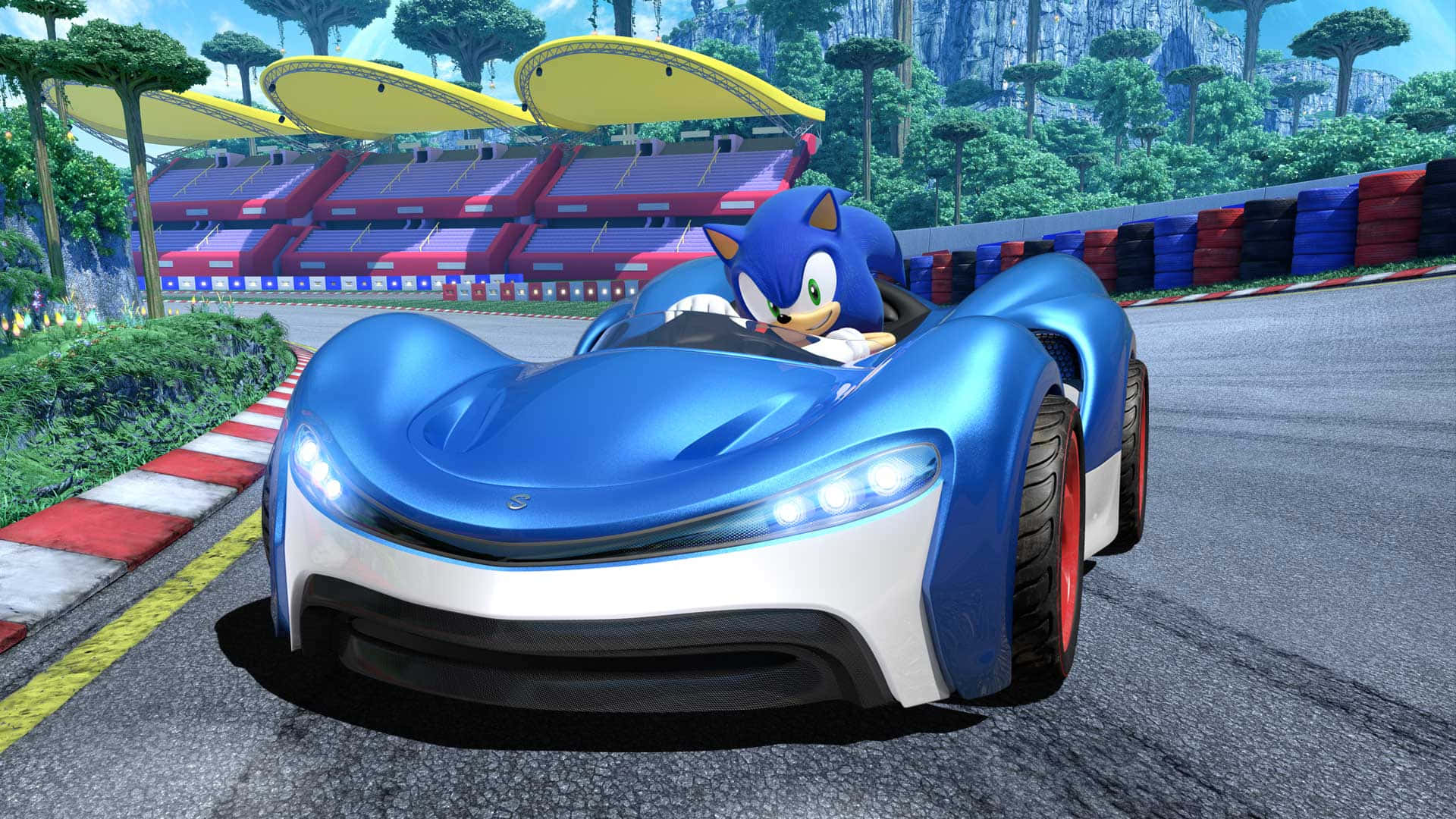 Sonic Battle Racers 桌布 壁紙 — 索尼克在一個充滿活力的賽道上，駕駛著時尚的藍白跑車，賽道旁有體育場座位和茂密的綠植。