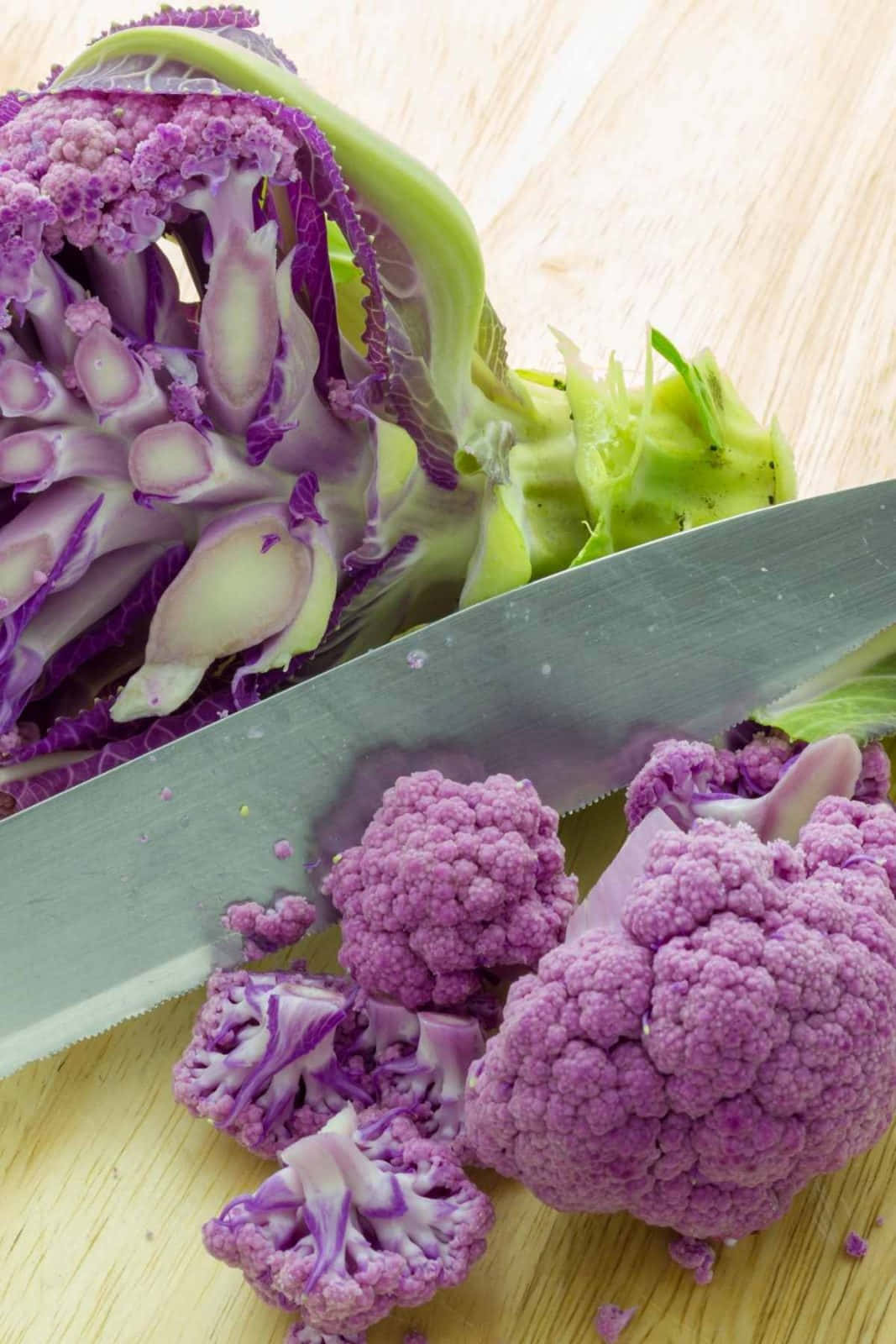 Purple Cauliflower 桌布 壁紙 — 紫椰菜花在木砧板上用鋒利刀切片的特寫。