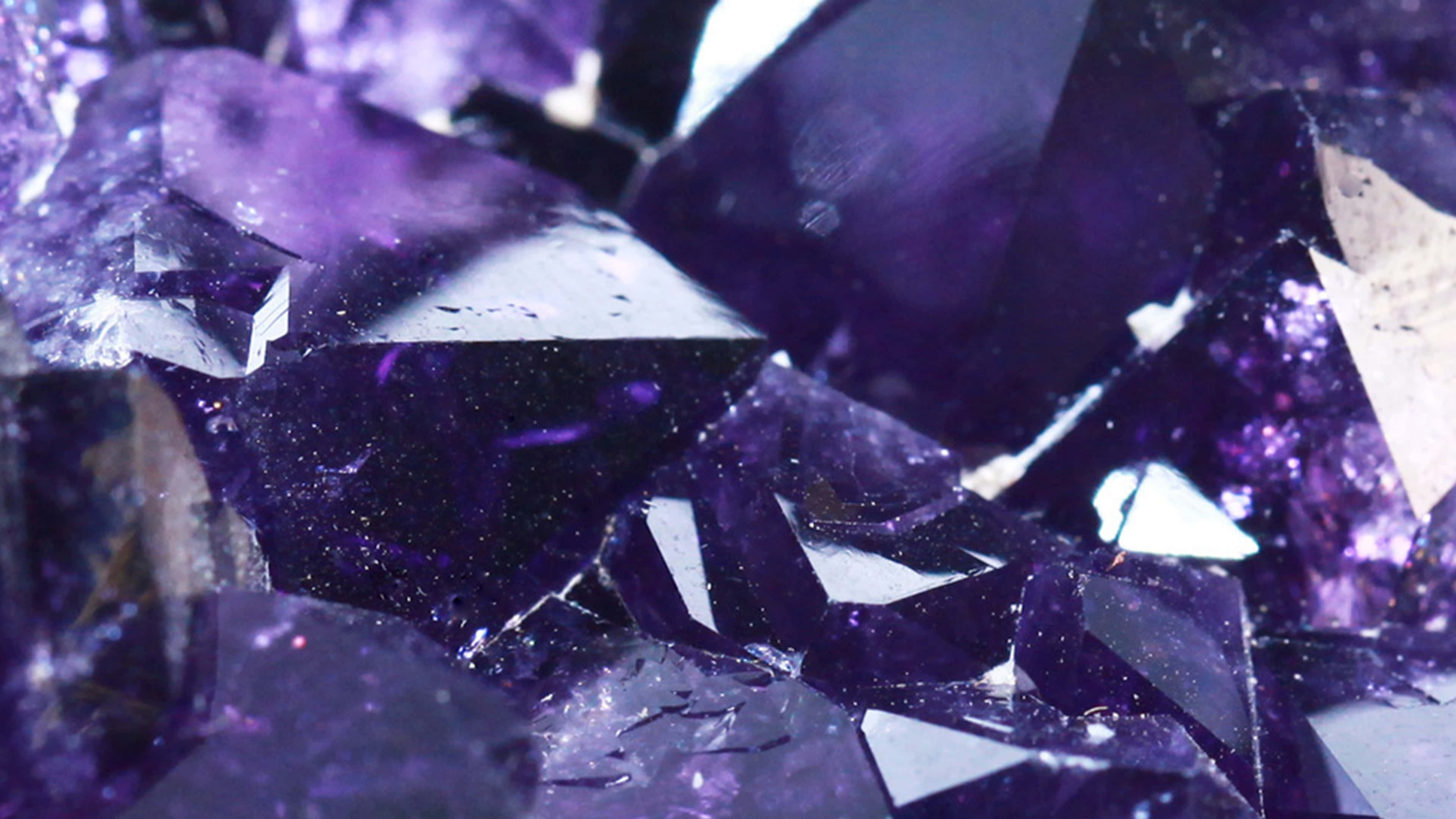 紫水晶 桌布 壁紙 — 紫水晶鋸齒狀晶體的近距離特寫，在柔和光線下散發深紫色調和閃爍切面。