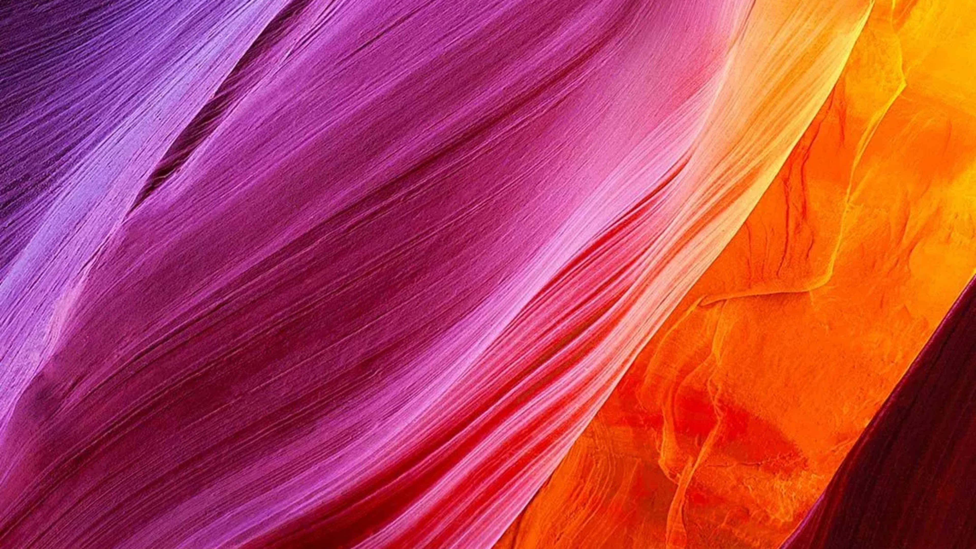 Xiaomi 桌布 壁紙 — 紫色、粉紅色和橙色的鮮豔漩渦帶創造出動態的抽象紋理，類似流動的布料或峽谷牆壁。