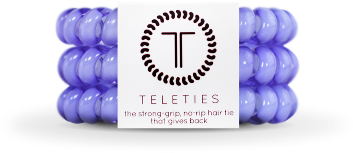 Product 桌布 壁紙 — 紫色Teleties髮圈以對稱圖案圍繞帶有品牌標誌和標語的白色標籤的產品照片。