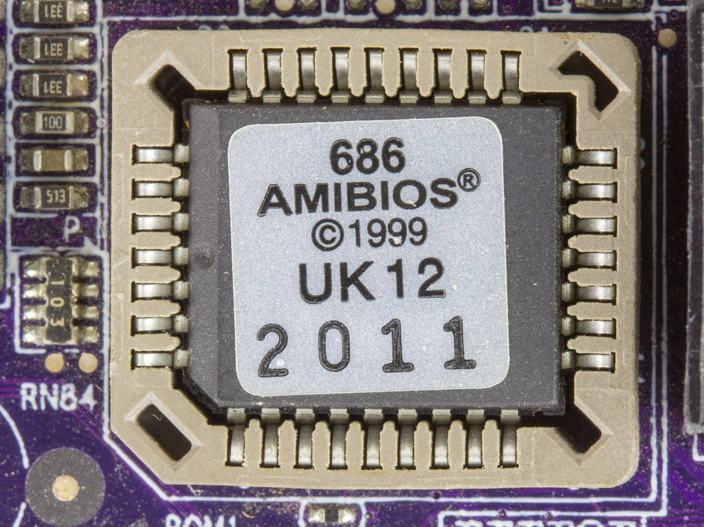 Motherboard 桌布 壁紙 — 紫色主機板上帶有可見焊盤和元件標記的復古AMIBIOS 686晶片特寫。