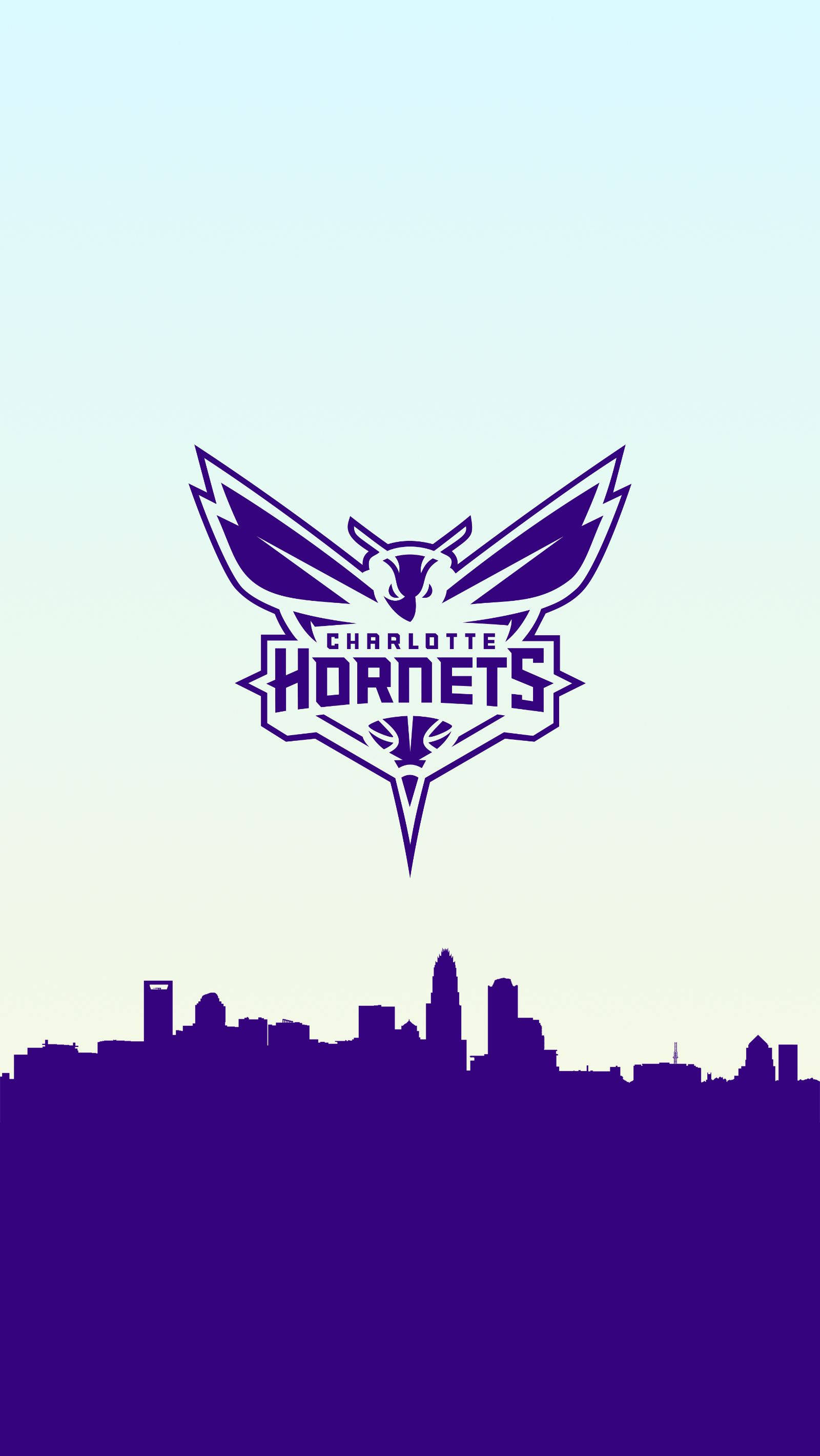 Hornets 桌布 壁紙 — 紫色和白色的夏洛特黃蜂隊標誌漂浮在城市天際線剪影之上，背景是漸變色的天空。