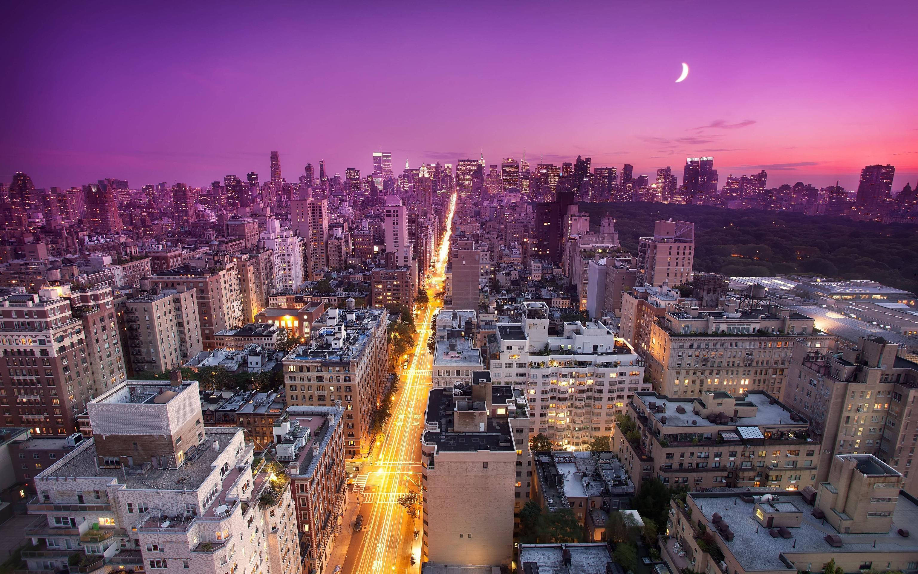 New York City Desktop 桌布 壁紙 — 紫色天空中帶有新月和發光街道的暮色城市鳥瞰圖。