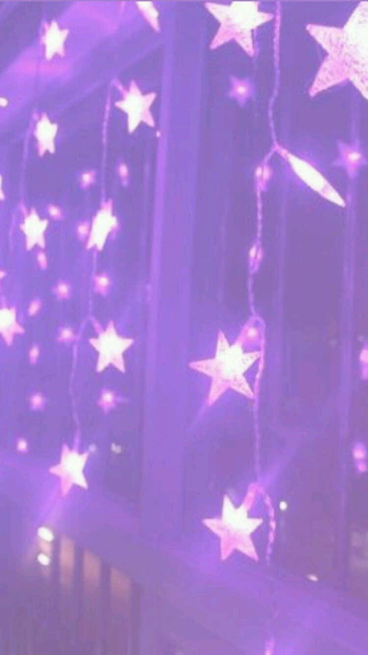 Lock Screen iPhone 桌布 壁紙 — 紫色星形燈串在舒適的室內環境中，對著深色窗框柔和地發光。