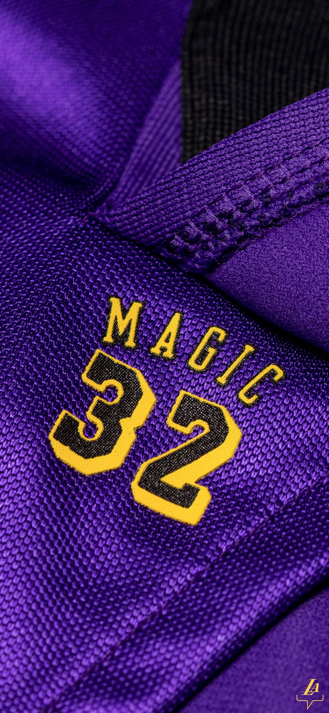 湖人 桌布 壁紙 — 紫色籃球球衣近距離特寫，帶有黃色 Magic 32 刺繡和黑色飾邊。