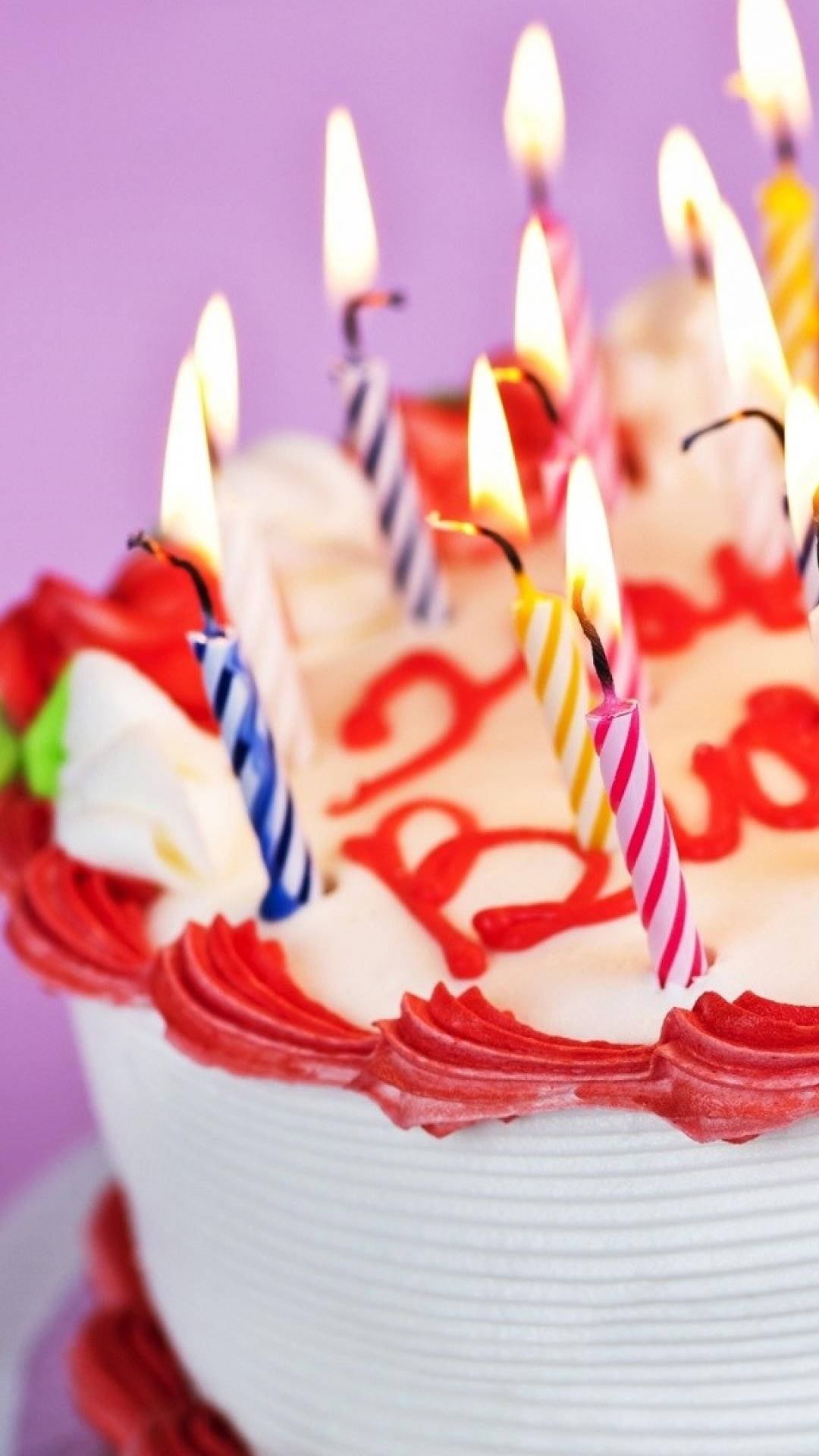 生日快樂 桌布 壁紙 — 紫色背景上，生日蛋糕的特寫，帶有燃燒的蠟燭和紅色糖霜文字。