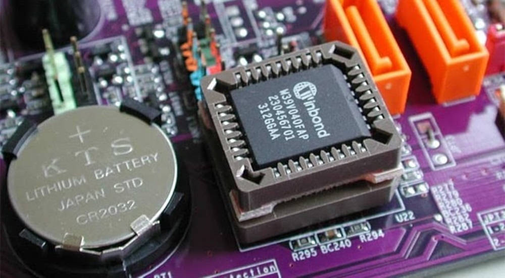Motherboard 桌布 壁紙 — 紫色電路板的特寫，具有鋰電池和帶有橙色連接器的黑色集成電路晶片。