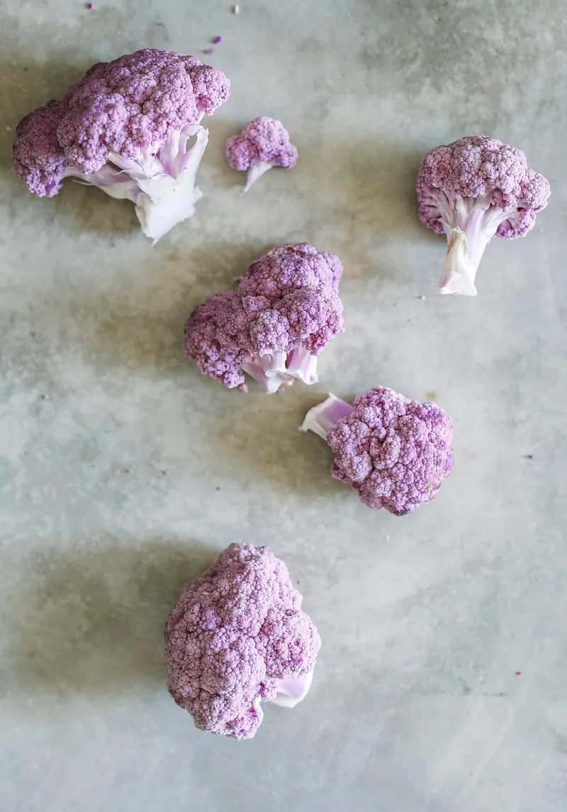 Purple Cauliflower 桌布 壁紙 — 紫花椰菜小朵散落在淺灰色紋理表面上，柔和自然光線。