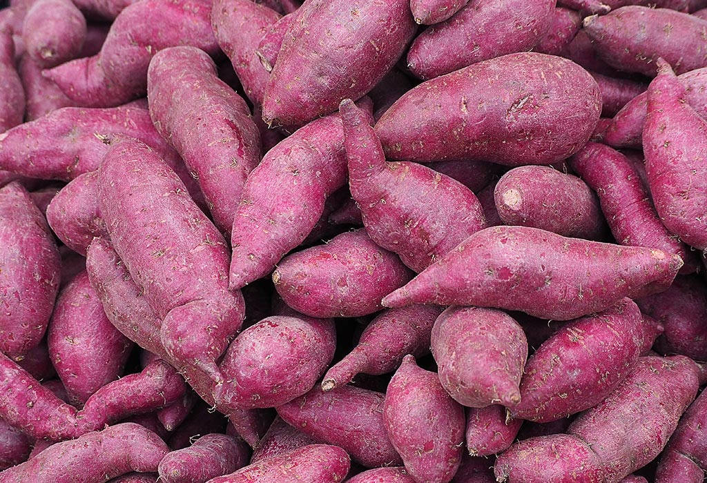Healthy Food 桌布 壁紙 — 紫薯堆疊在一起的近距離特寫，顯示出紋理表皮和自然瑕疵。