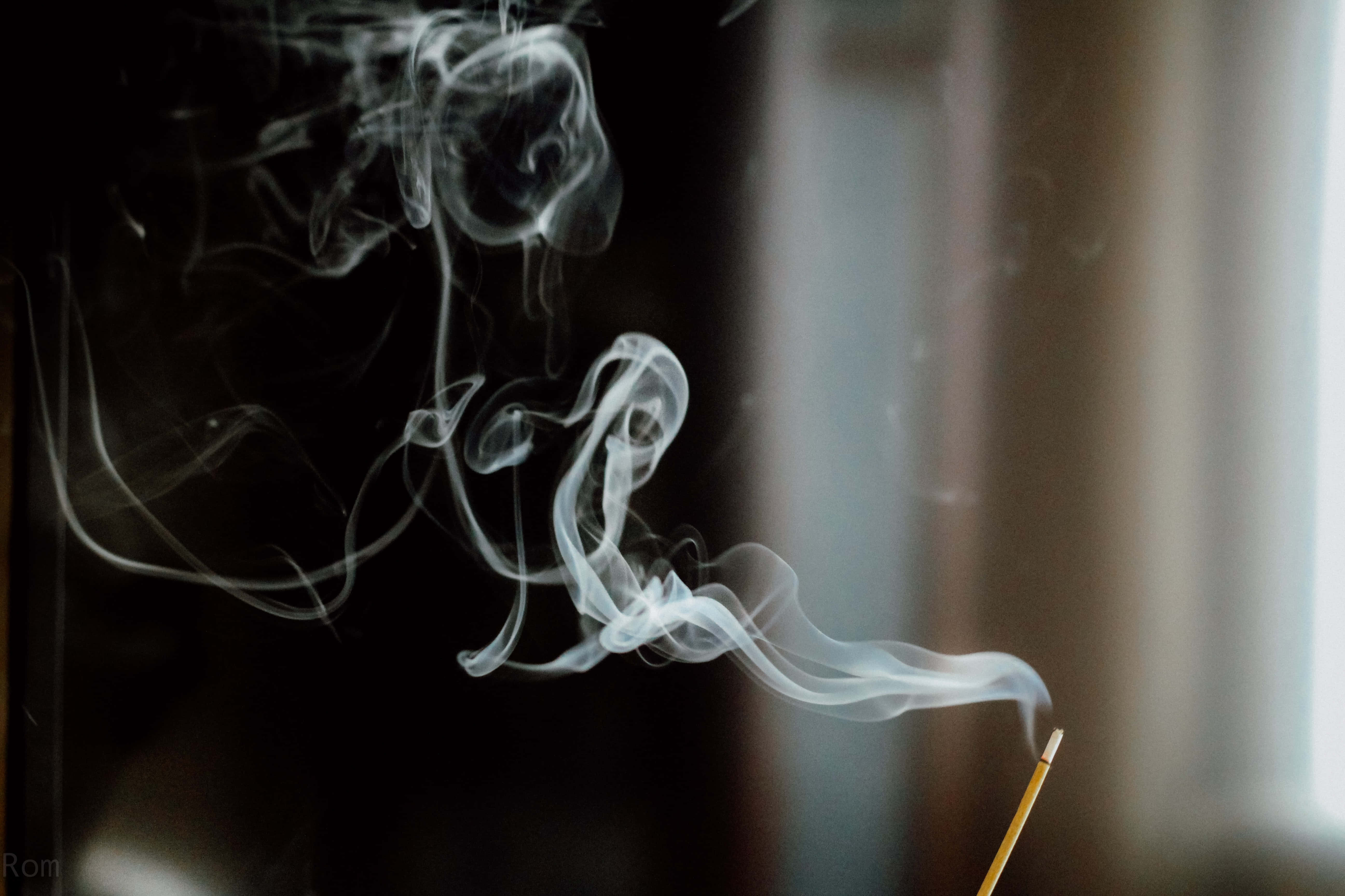 Smokey 桌布 壁紙 — 細緻的白煙香薰在柔和光線下，於黑暗模糊的背景中優雅地盤旋。